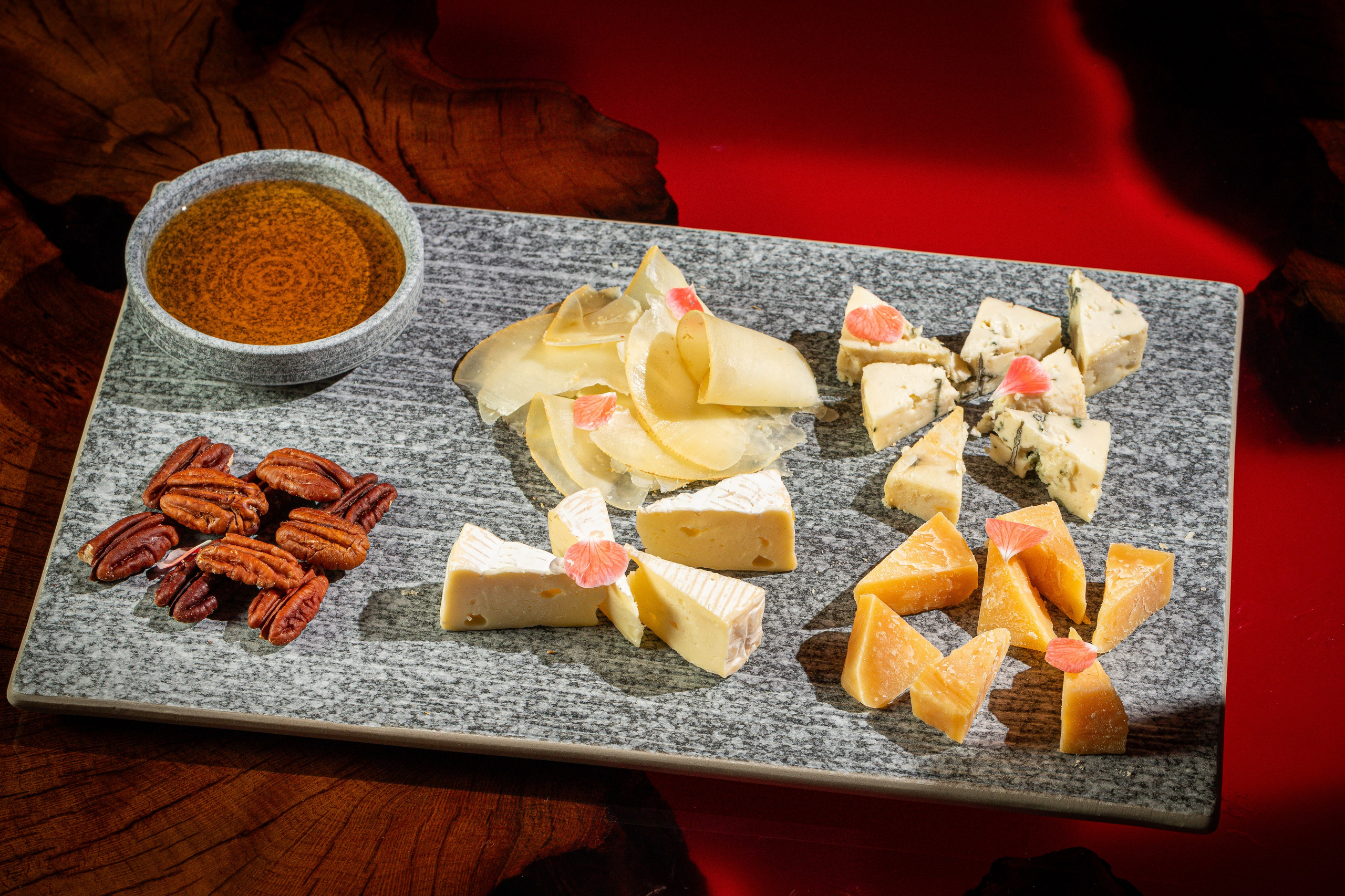 Подача сырной тарелки с несколькими видами сыров