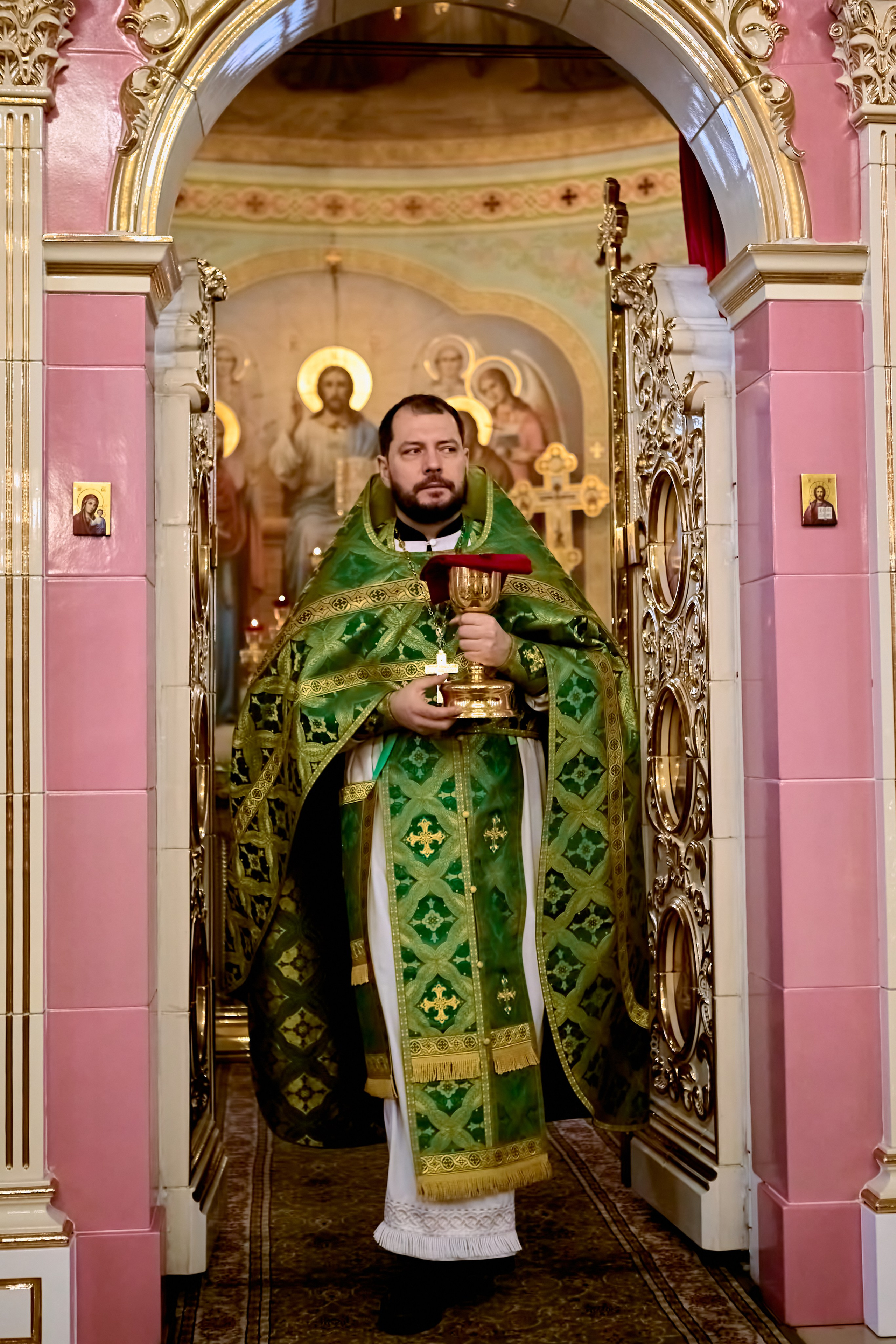 Священник выходит с чашей для причастия прихожан