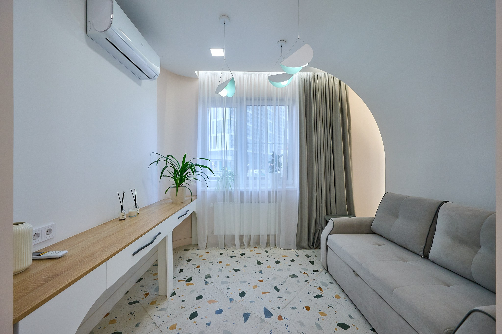 гостиная серый диван светлые обои  белая тумбочка серые шторы 