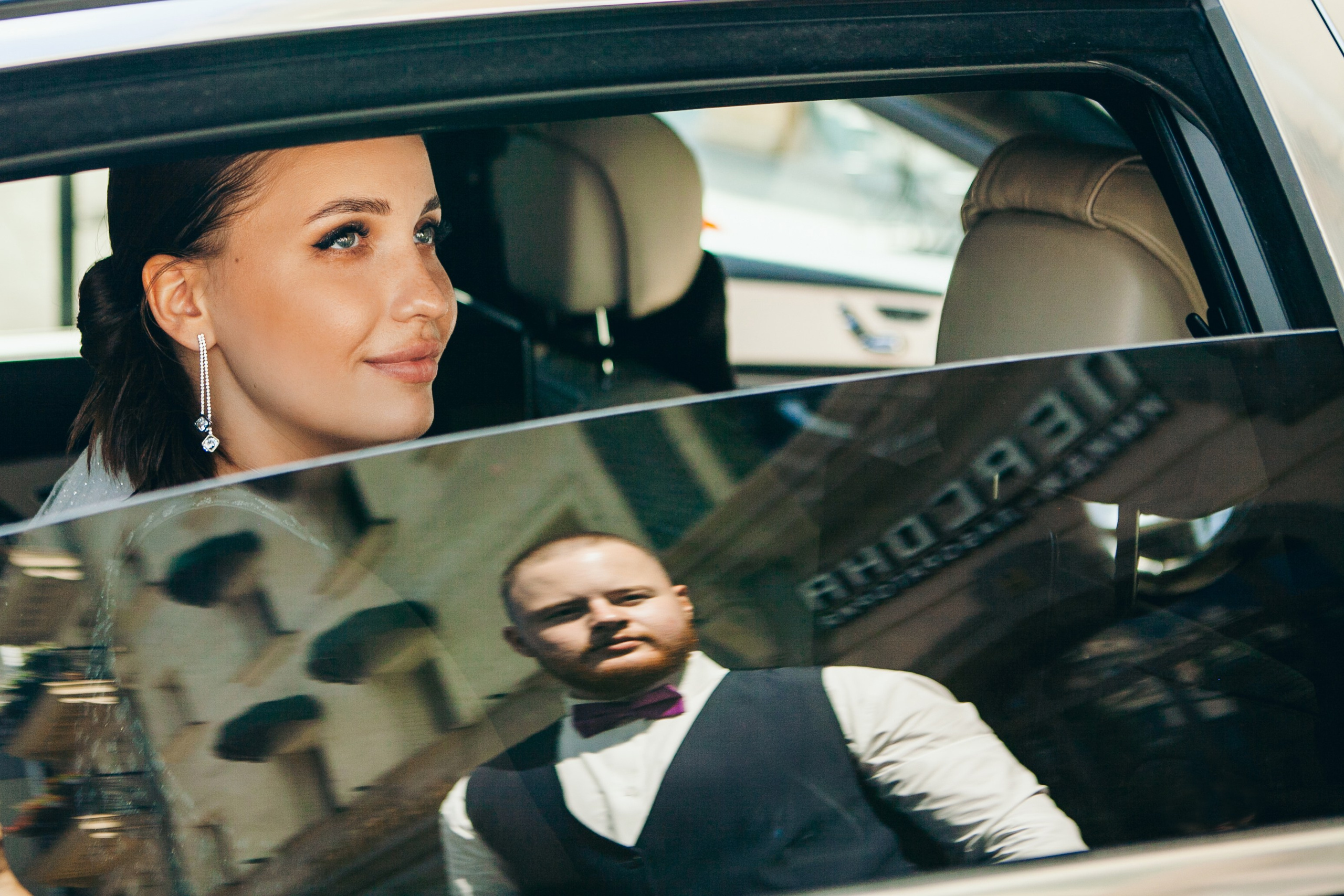 невеста сидит в машине и жених отображается в окне 