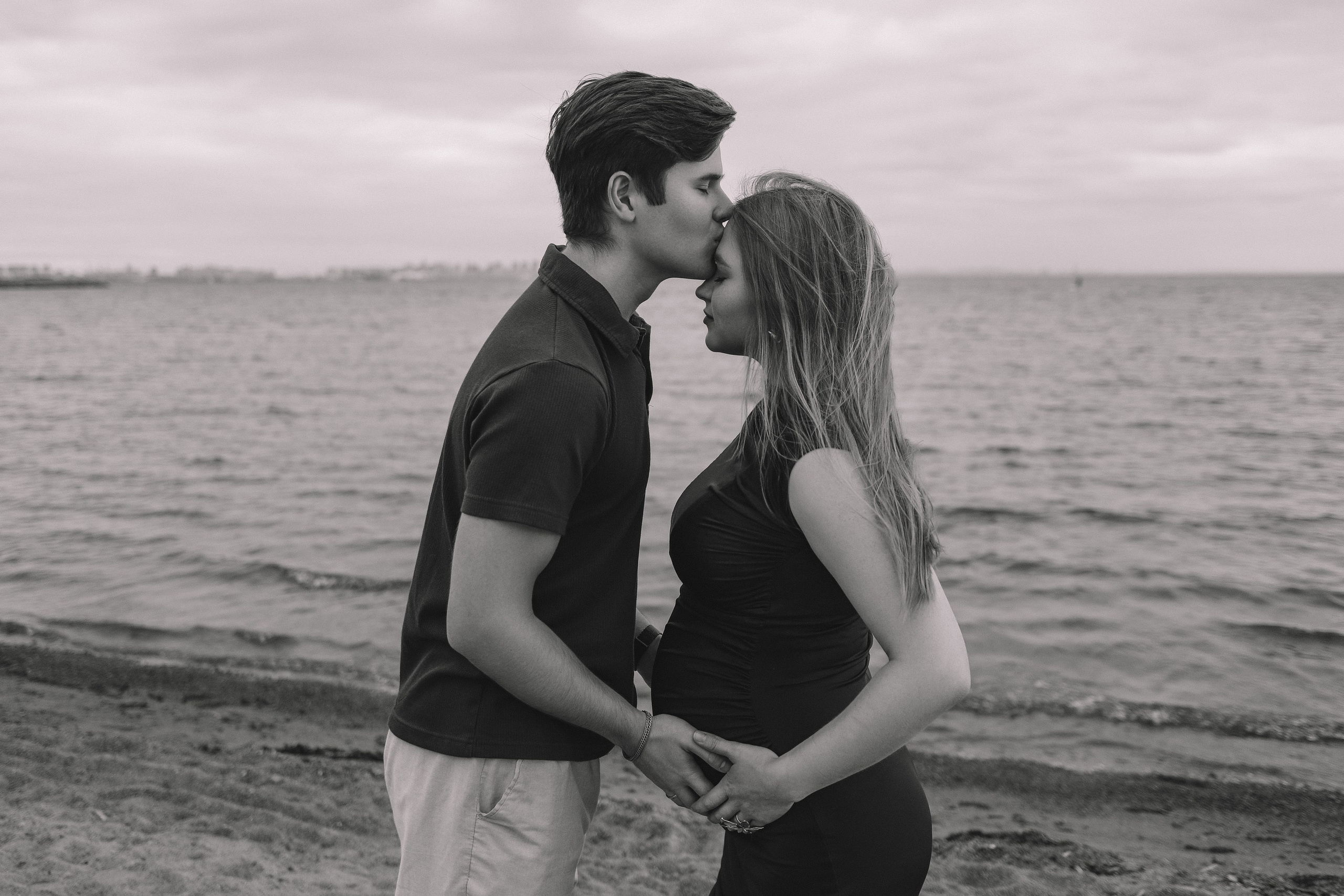 Пара держится за руки у воды, черно-белое фото