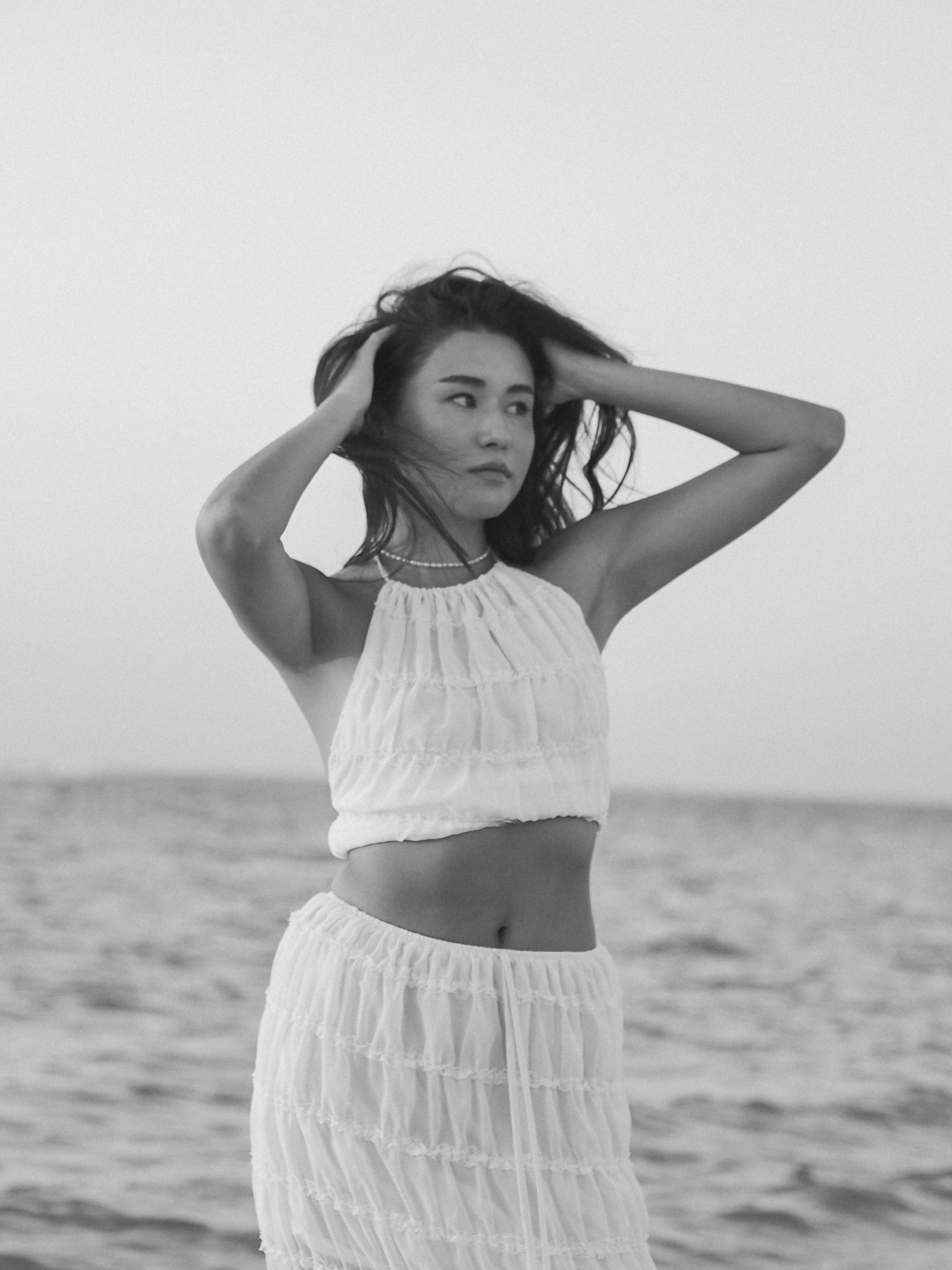 Черно-белая фотография красивой девушки на пляже.