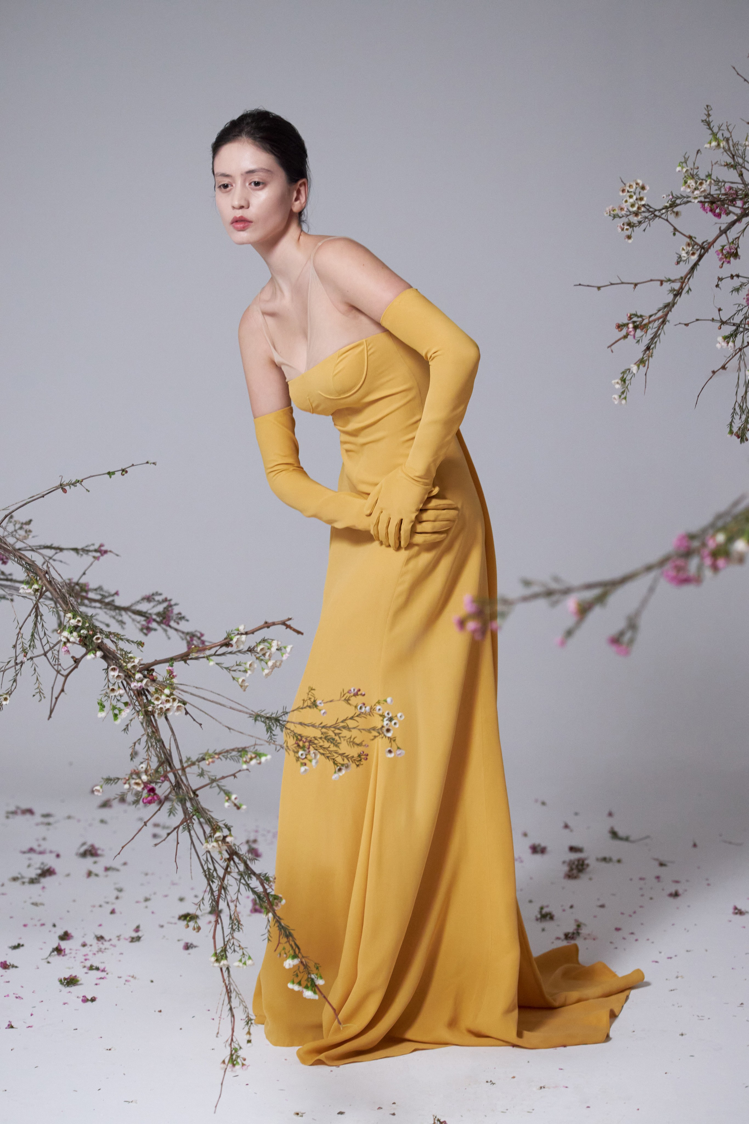 Портрет девушки-азиатки в полный рост среди цветущих веток