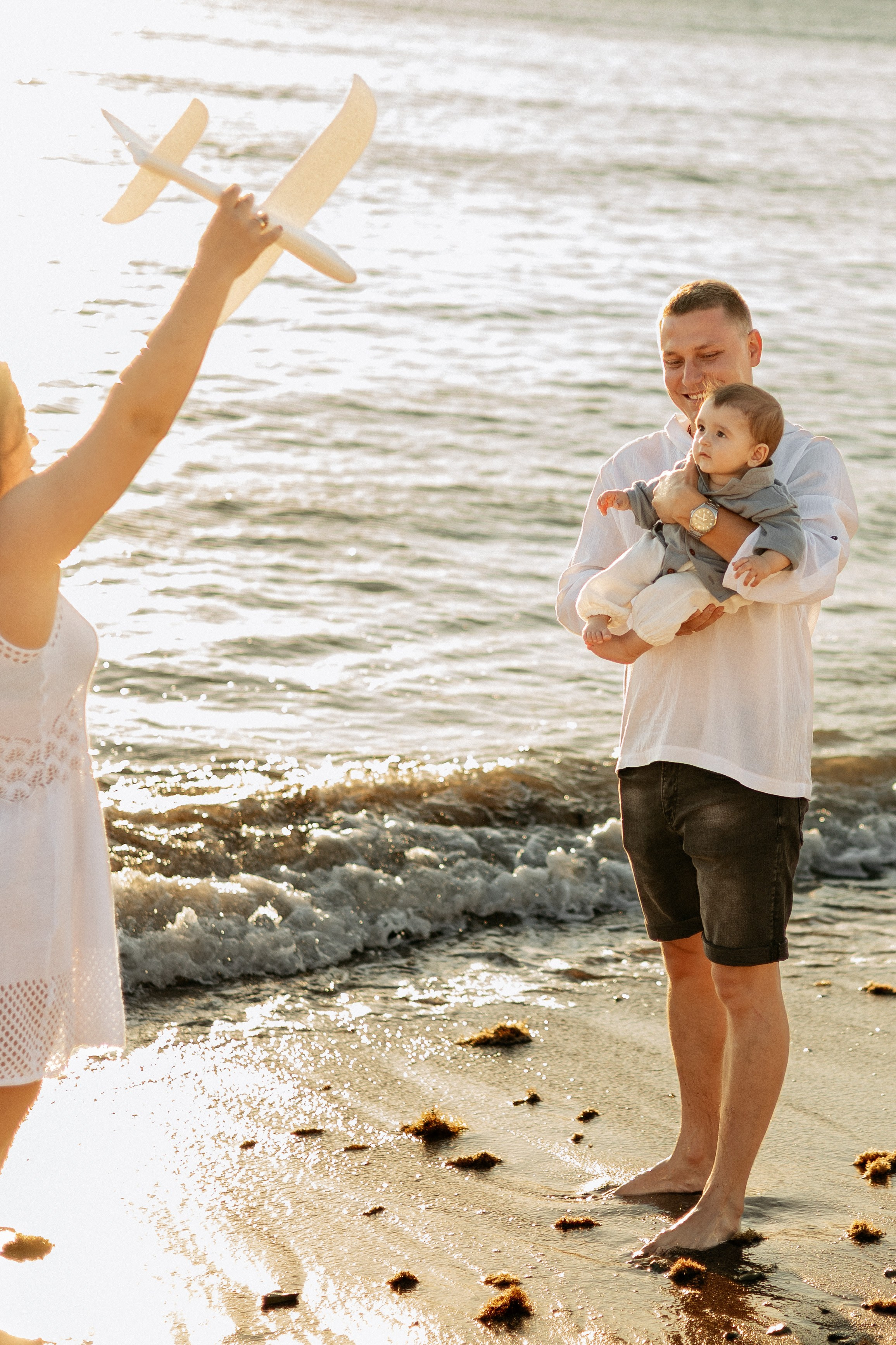 Радостный момент: родители и сын запускают бумажные самолетики в небо