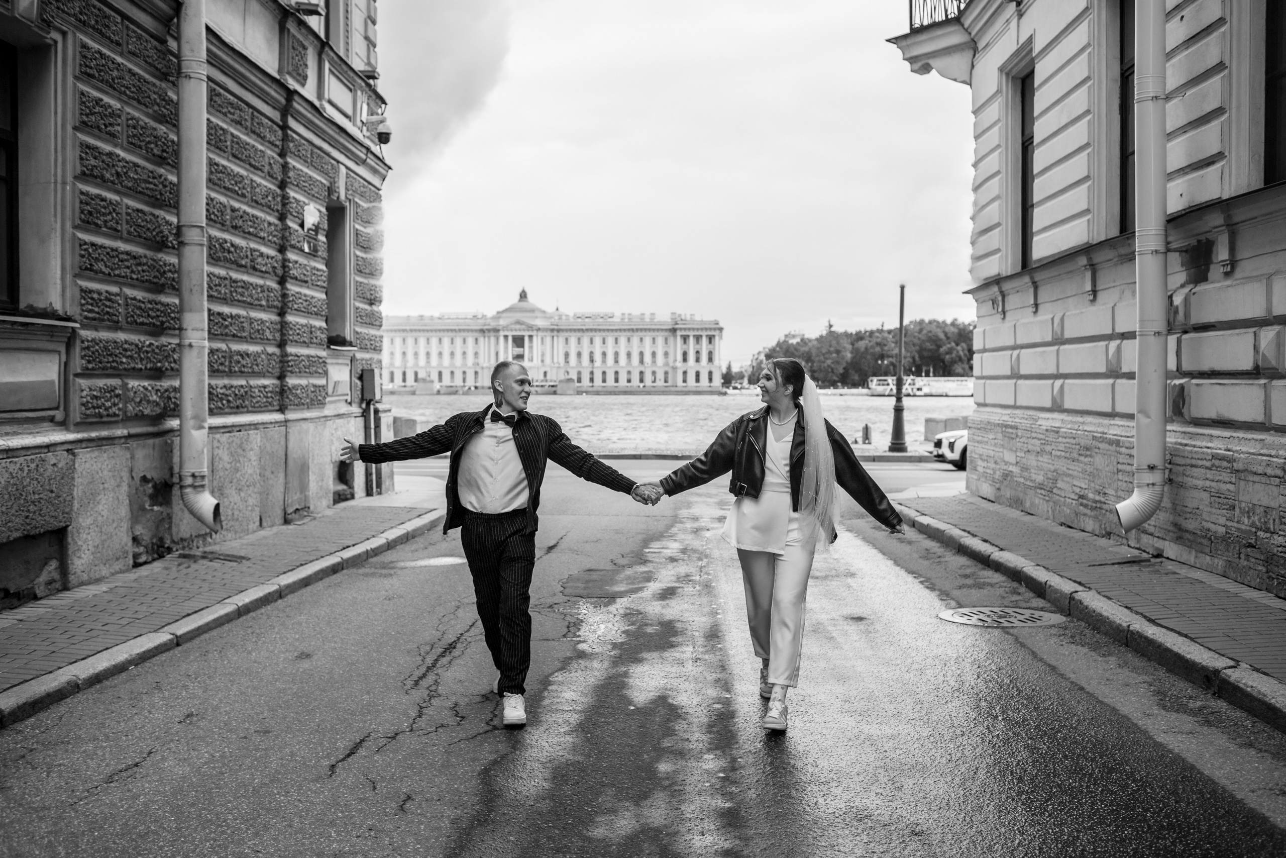 Интересная идея для свадебной фотографии: жених и невеста идут за руку по пустой улице.