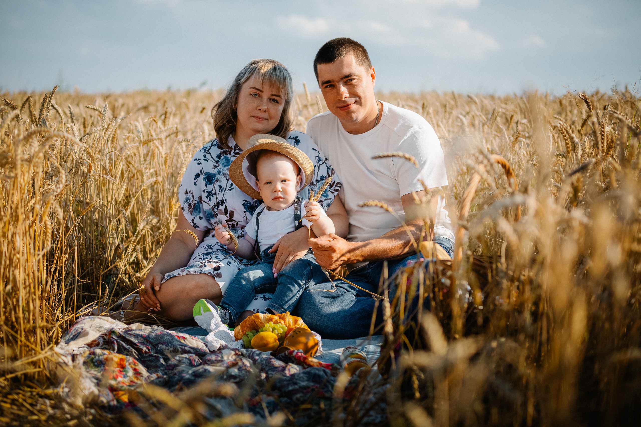 Семейная пара на пикнике посреди колосьев