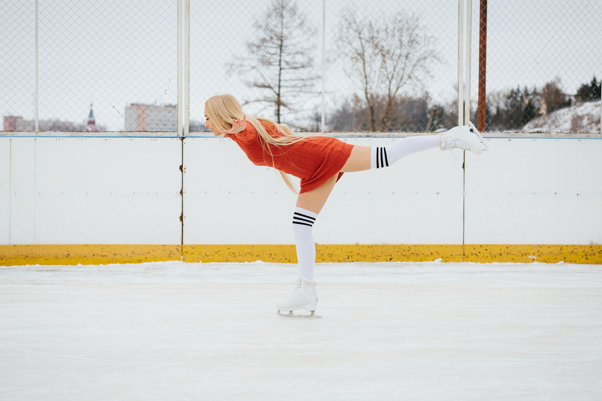 Женщина стоит на одной ноге на льду в наклоне