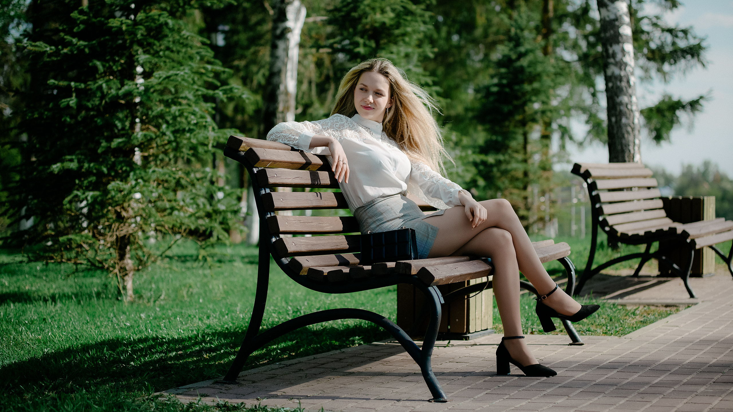 Блондинка в расслабленной позе на скамейке во Ржеве
