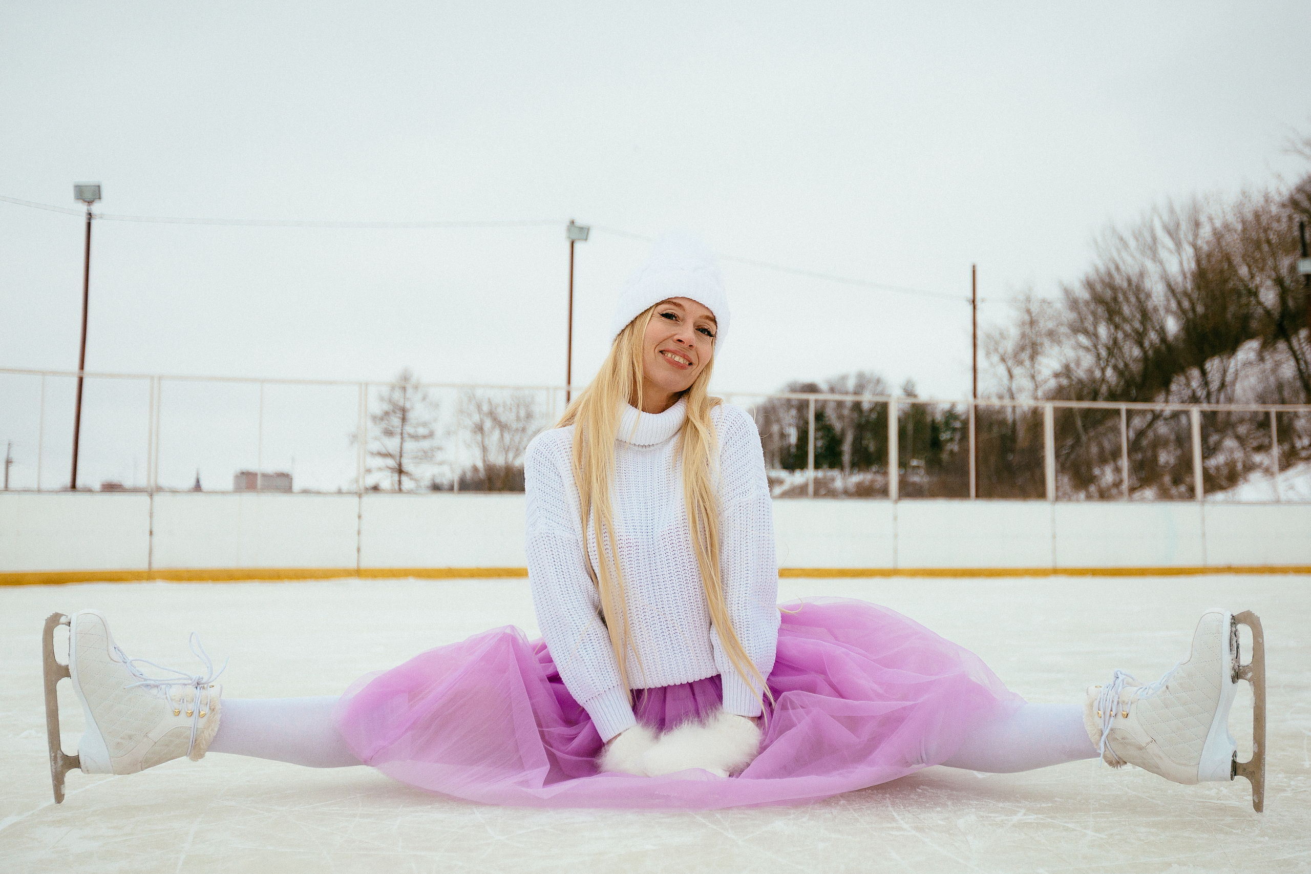 Женщина в сиреневой юбке сидит на льду