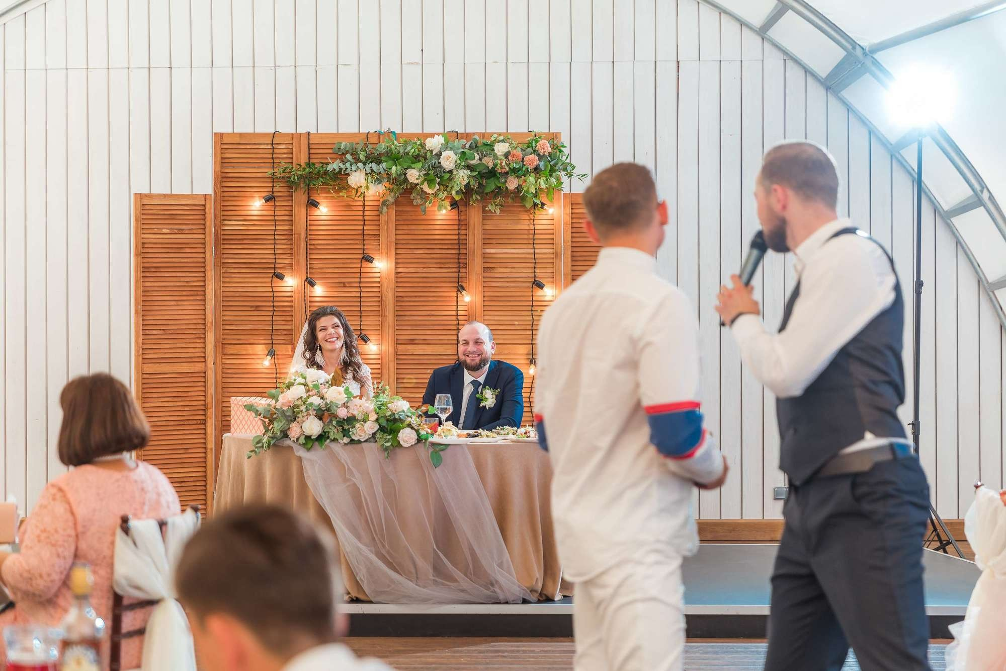 Молодожены смеются на свадебной вечеринке