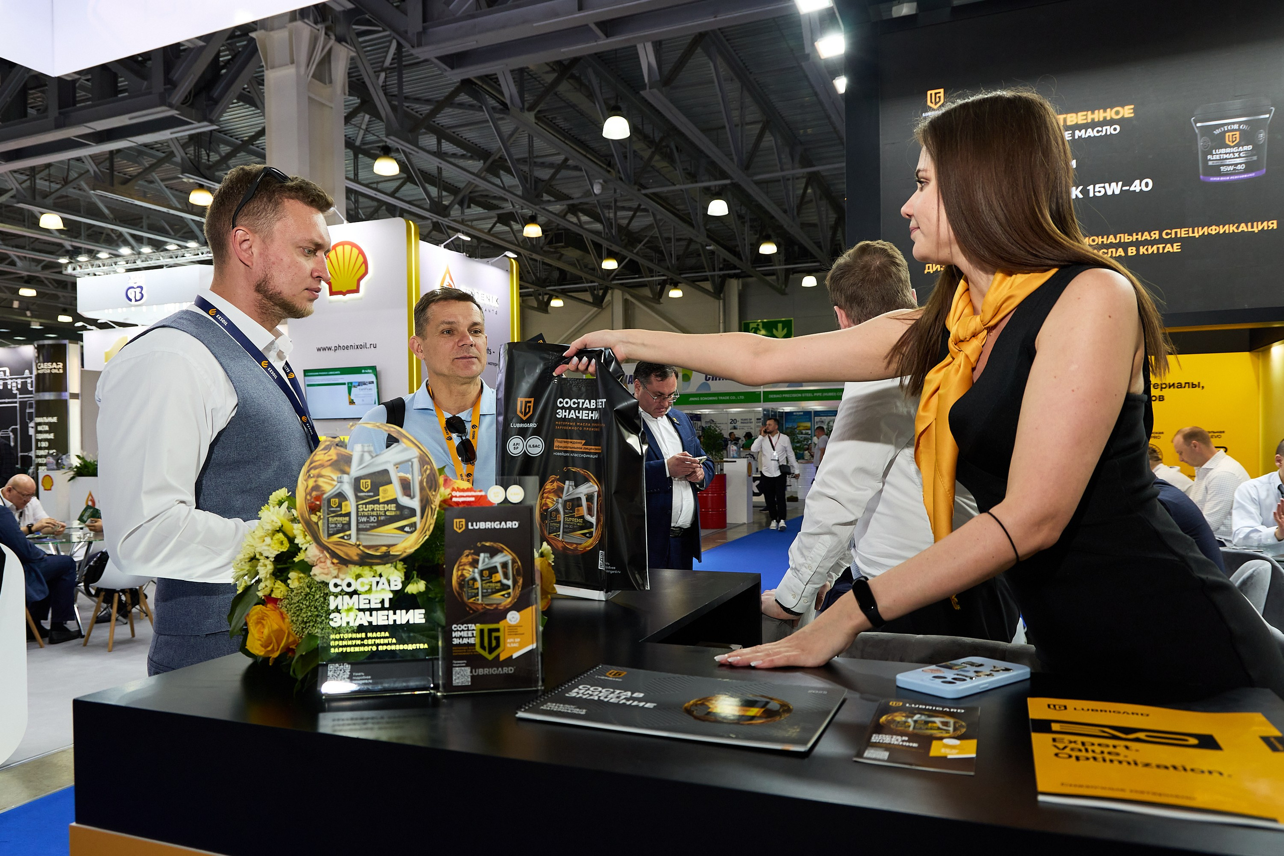 красивые девушки передают рекламную продукцию клиенту на выставке