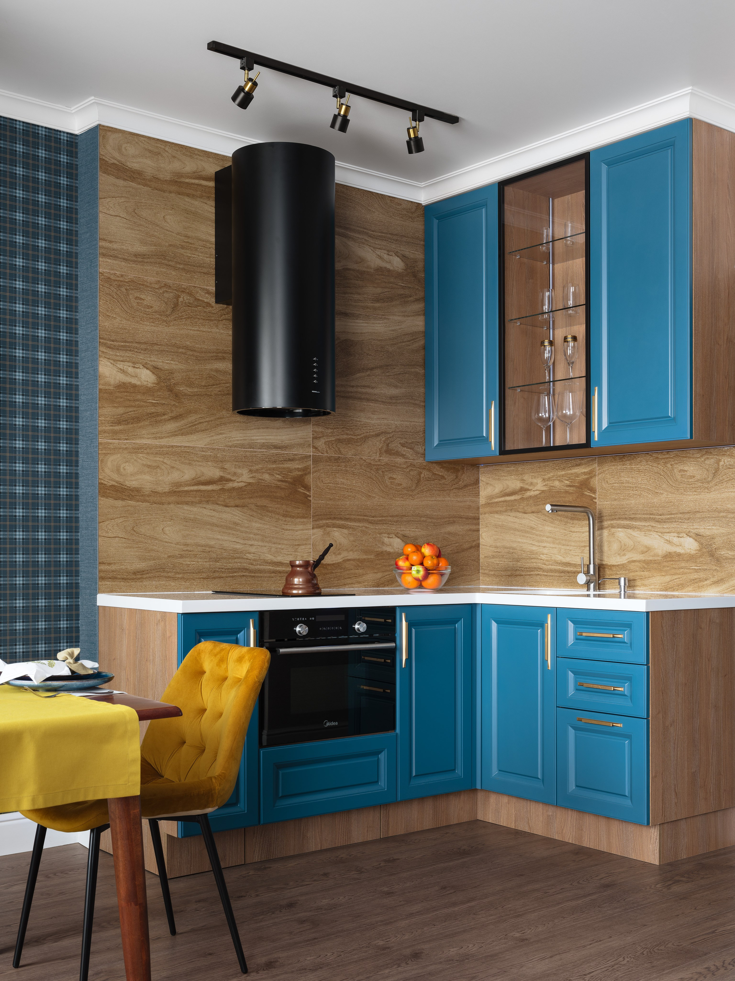 Современный дизайн интерьера кухни в ярком стиле с синими фасадами, деревянными акцентами и уютной атмосферой. Фото подчеркивает гармонию цвета и уюта в интерьере. Дизайнер Лилия Горожеева, фотограф Сергей Денисенко.