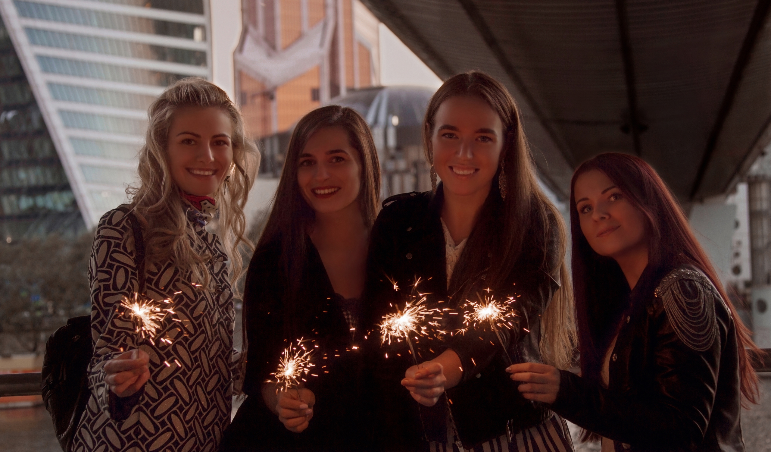 Фото прогулка в стиле девичник, девушки держат бенгальские огни под мостом в центре города в Москва сити.