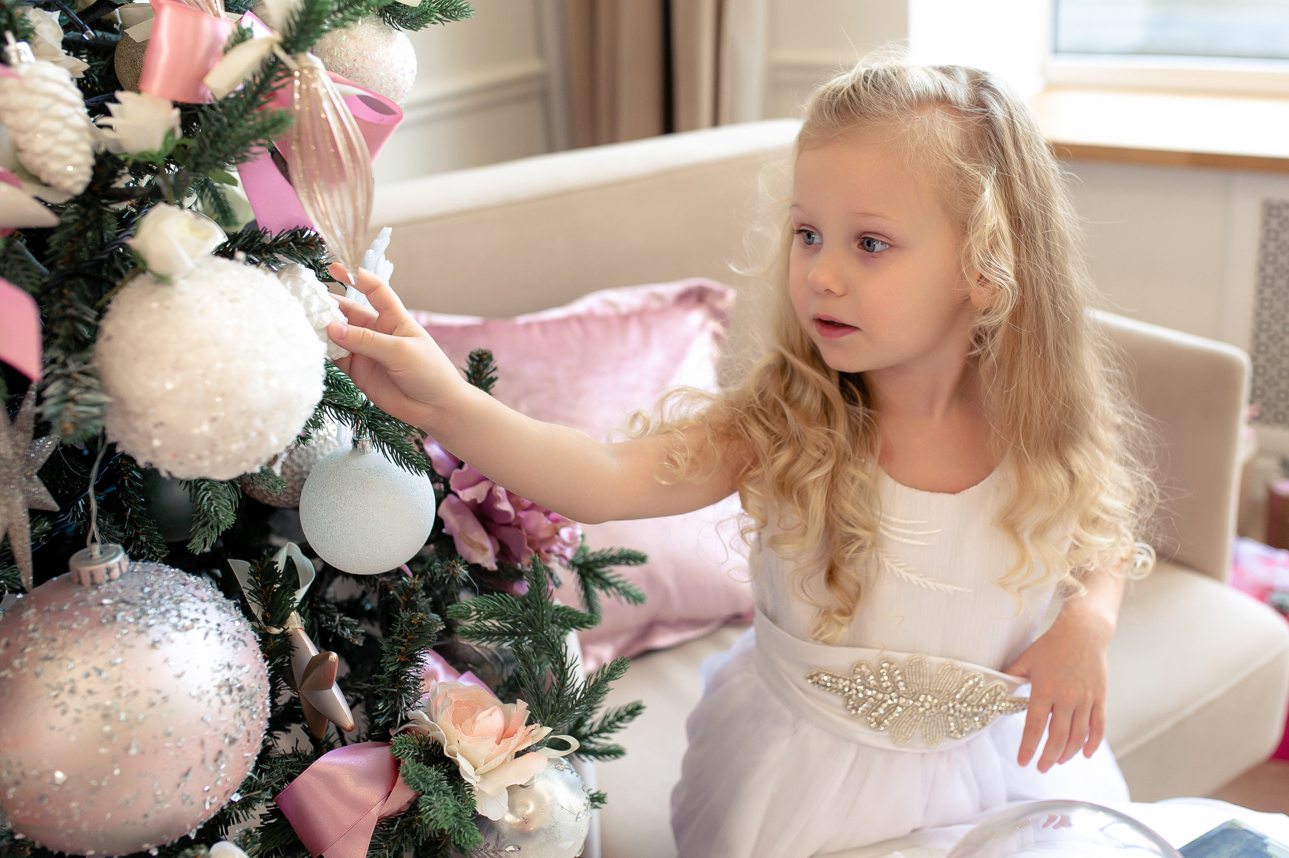 малышка рассматривает елку в фотостудии