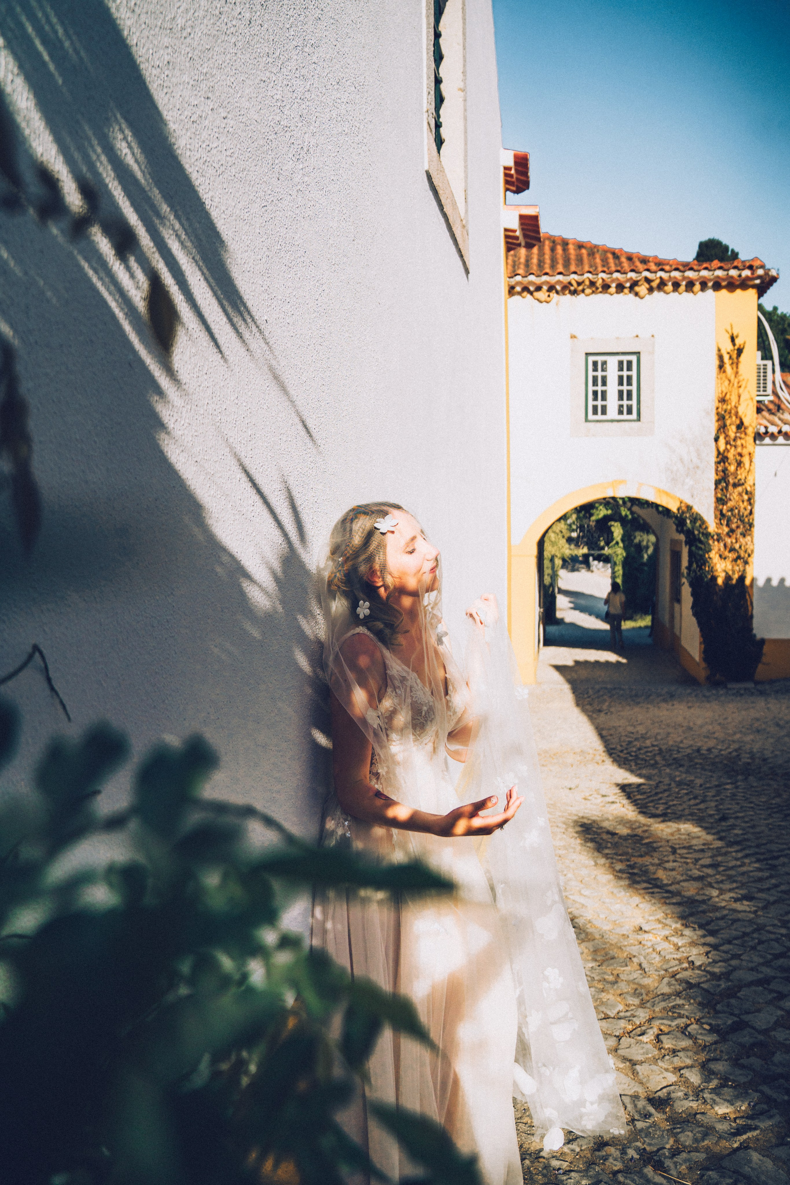 Влюбленная  пара жених и невеста целуется и обнимаются на фоне старинных улочек Португалии