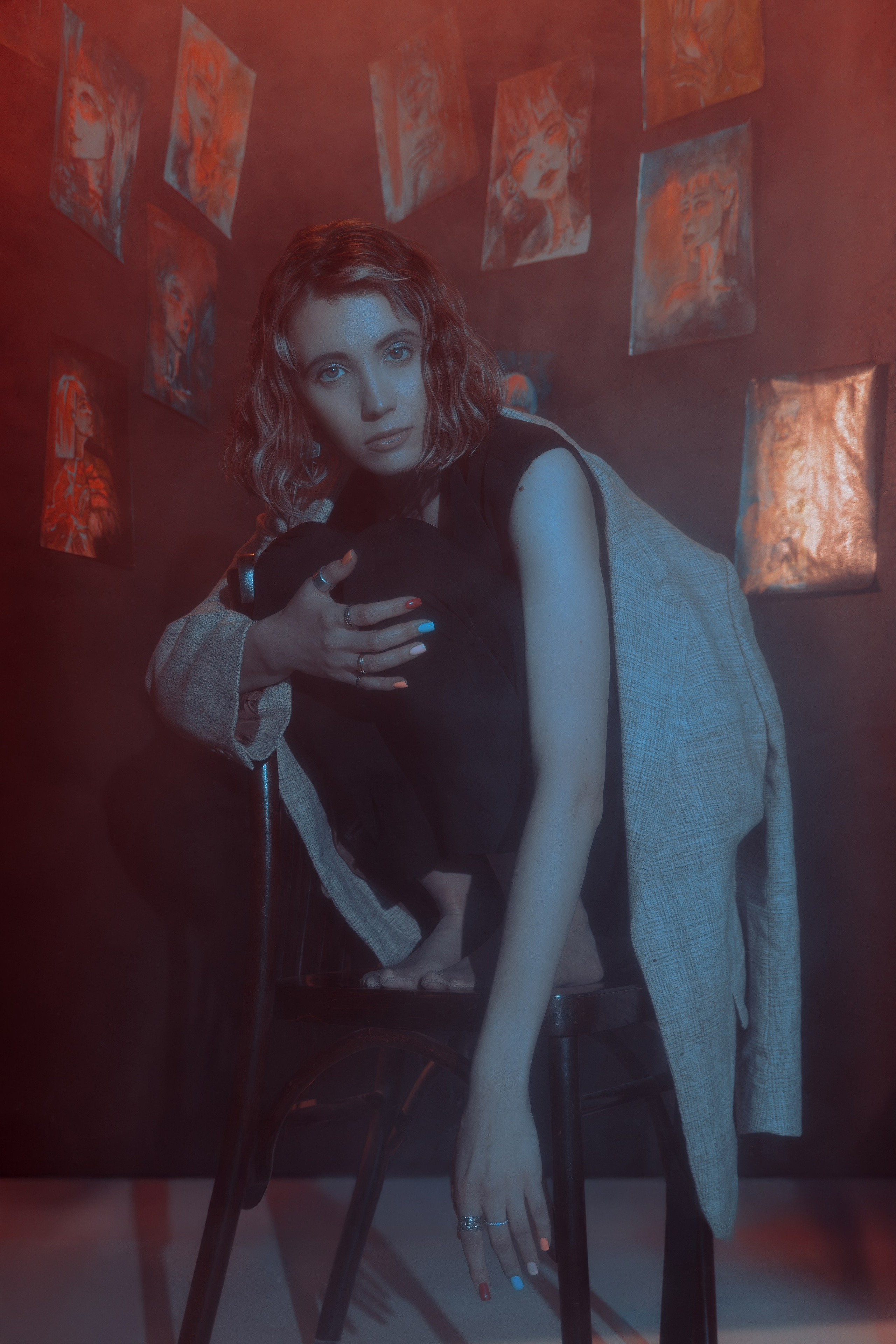 Лана сидит в узком углу в окружении своих работ