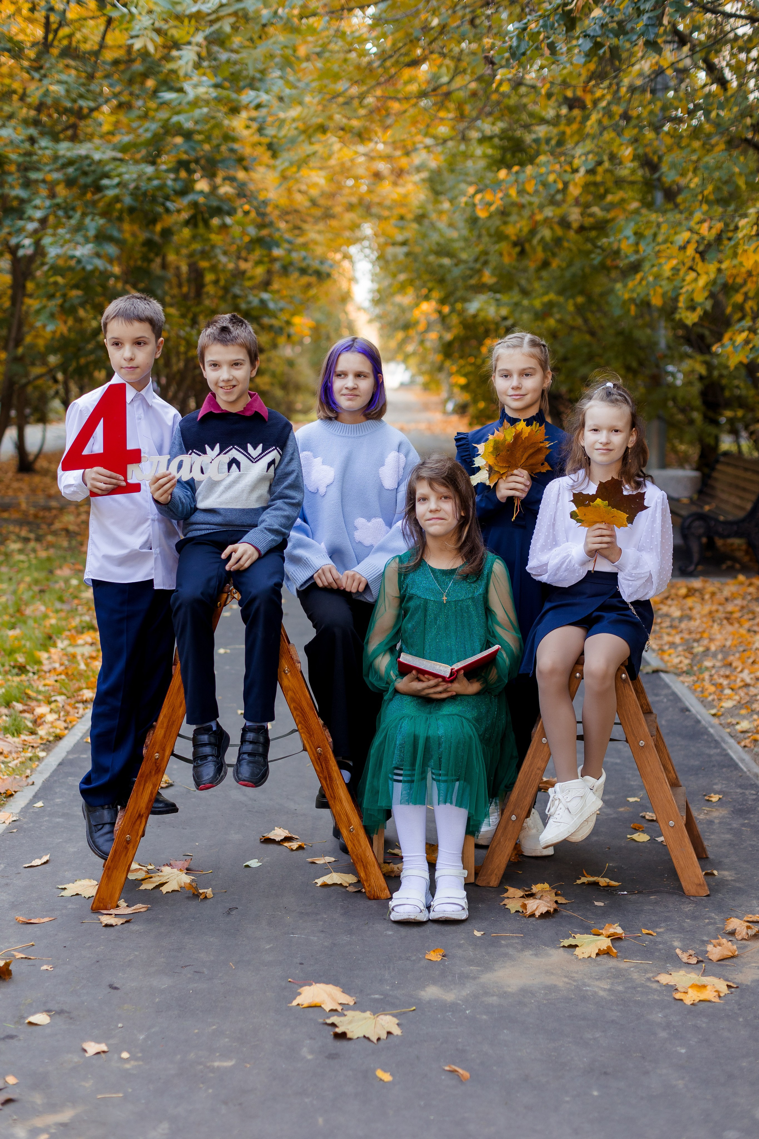 Компания одноклассников фотографируется вместе в осеннем парке