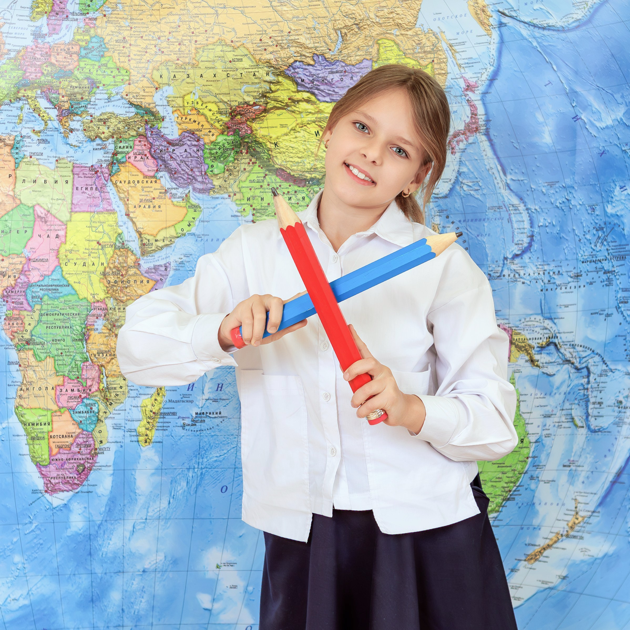 Девочка держит линейку и глобус, школьный портрет на фоне карты