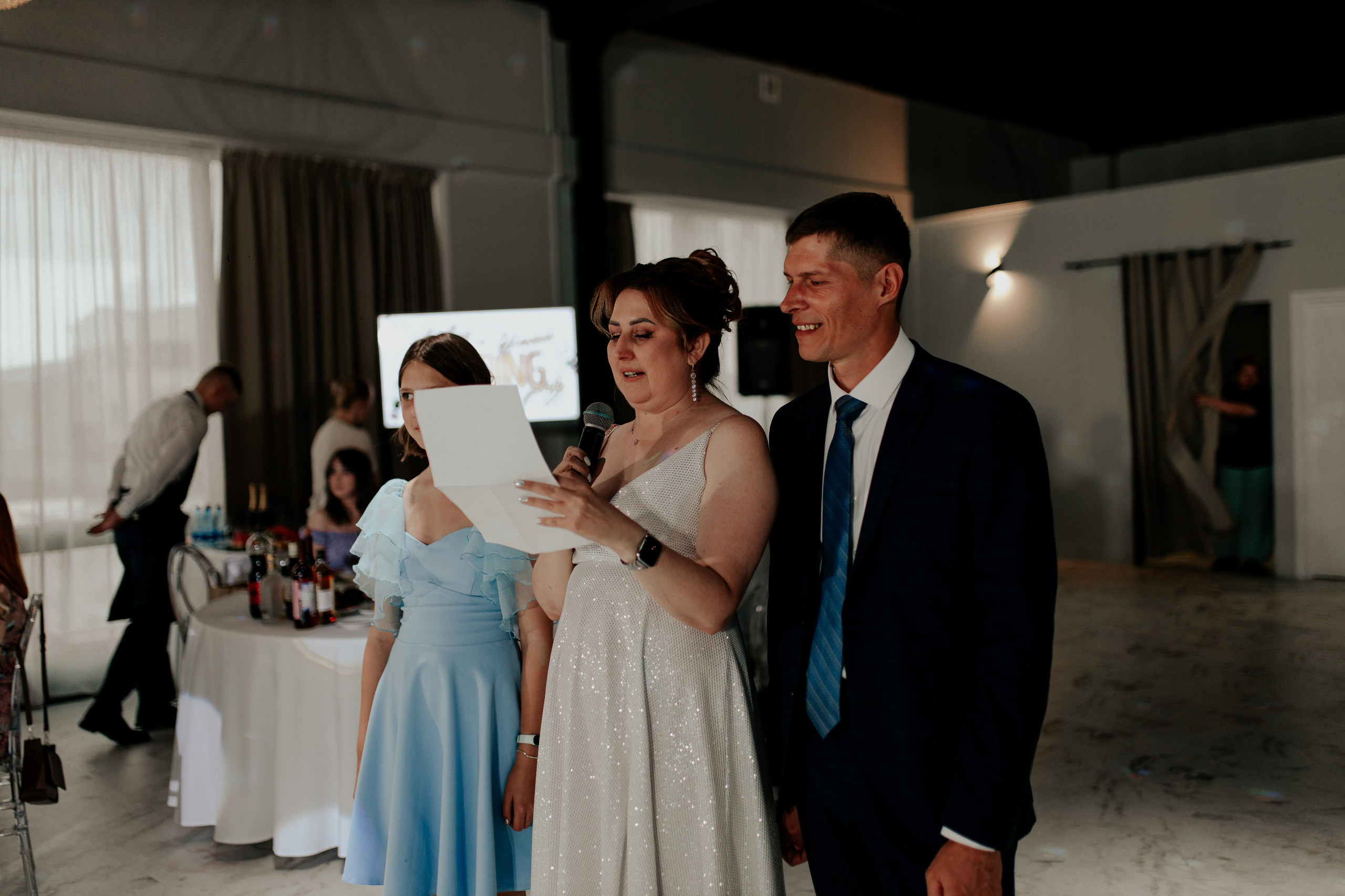 Родители молодожёнов обнимаются вечером на банкете — душевная встреча