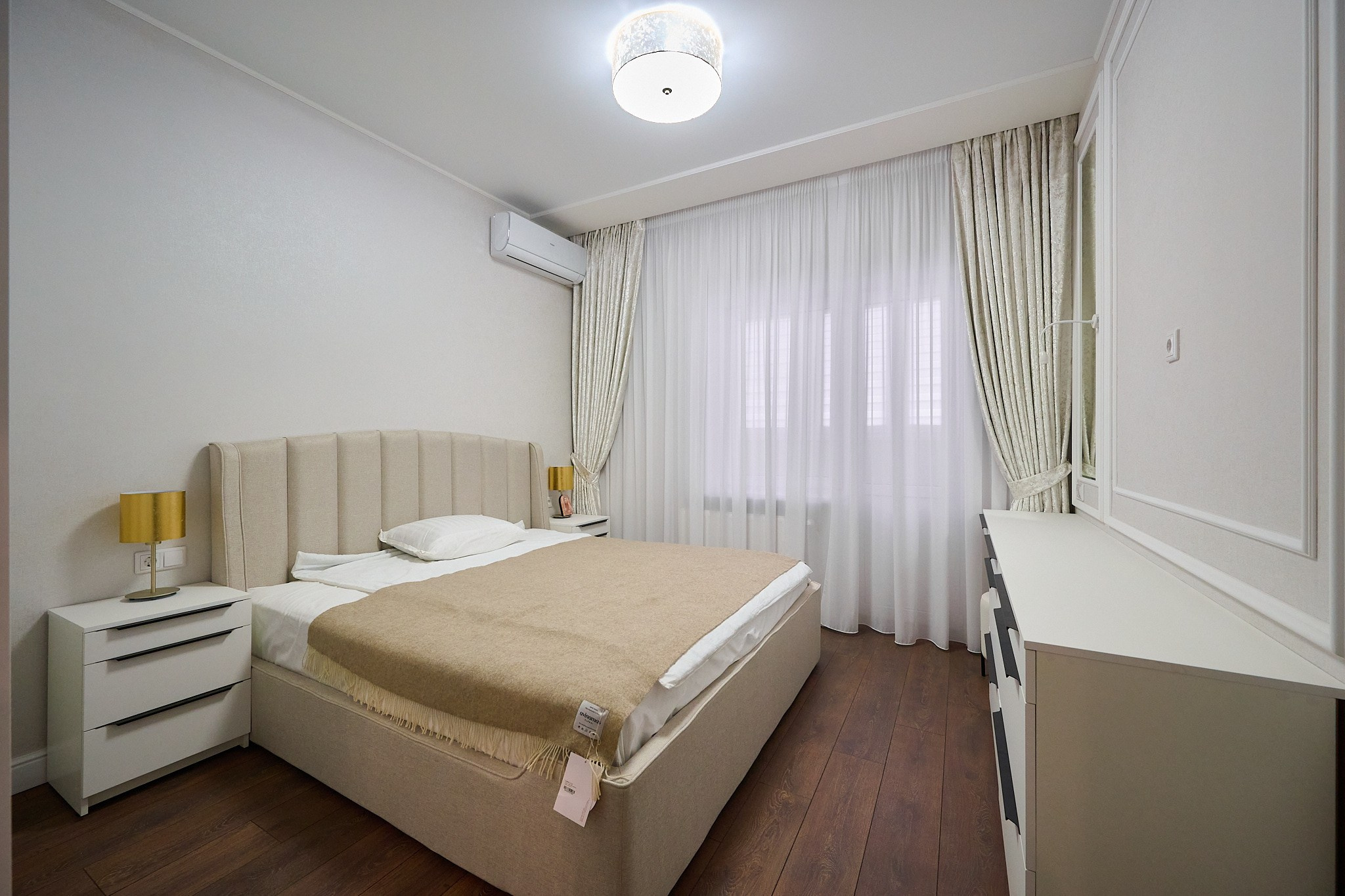 светлая комната с белыми шторами и шкафами 