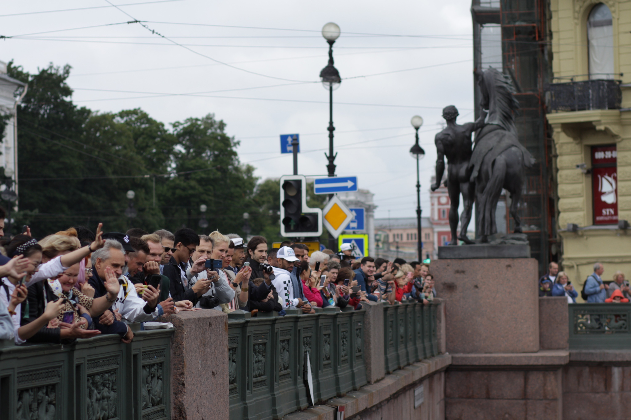 Люди на Аничковом мосту смотрят на реку Фонтанку во время фестиваля Фонтанка-SUP