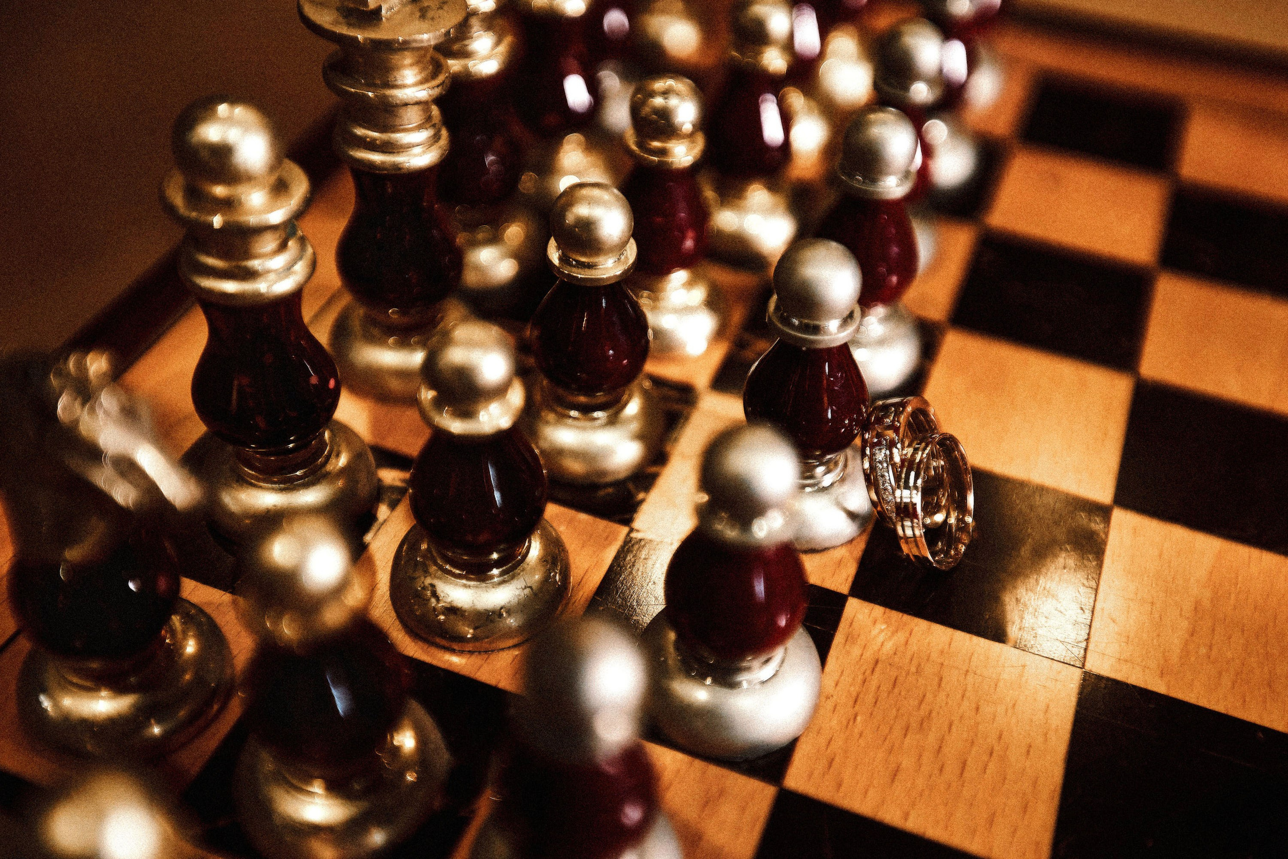 Обручальные кольца на шахматной доске, символика брака и союза