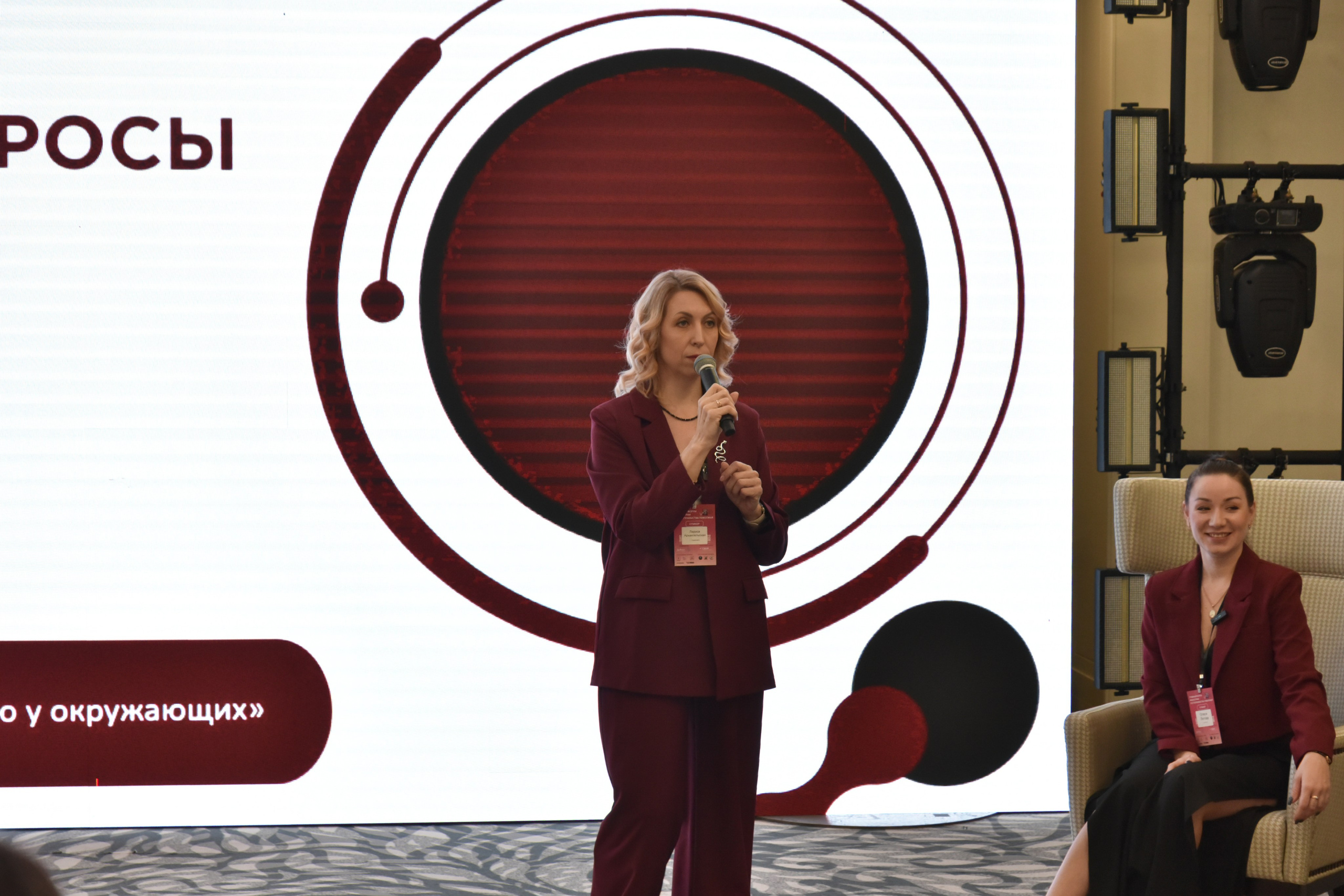 Репортаж с конференции.Спикер -женщина с микрофоном 