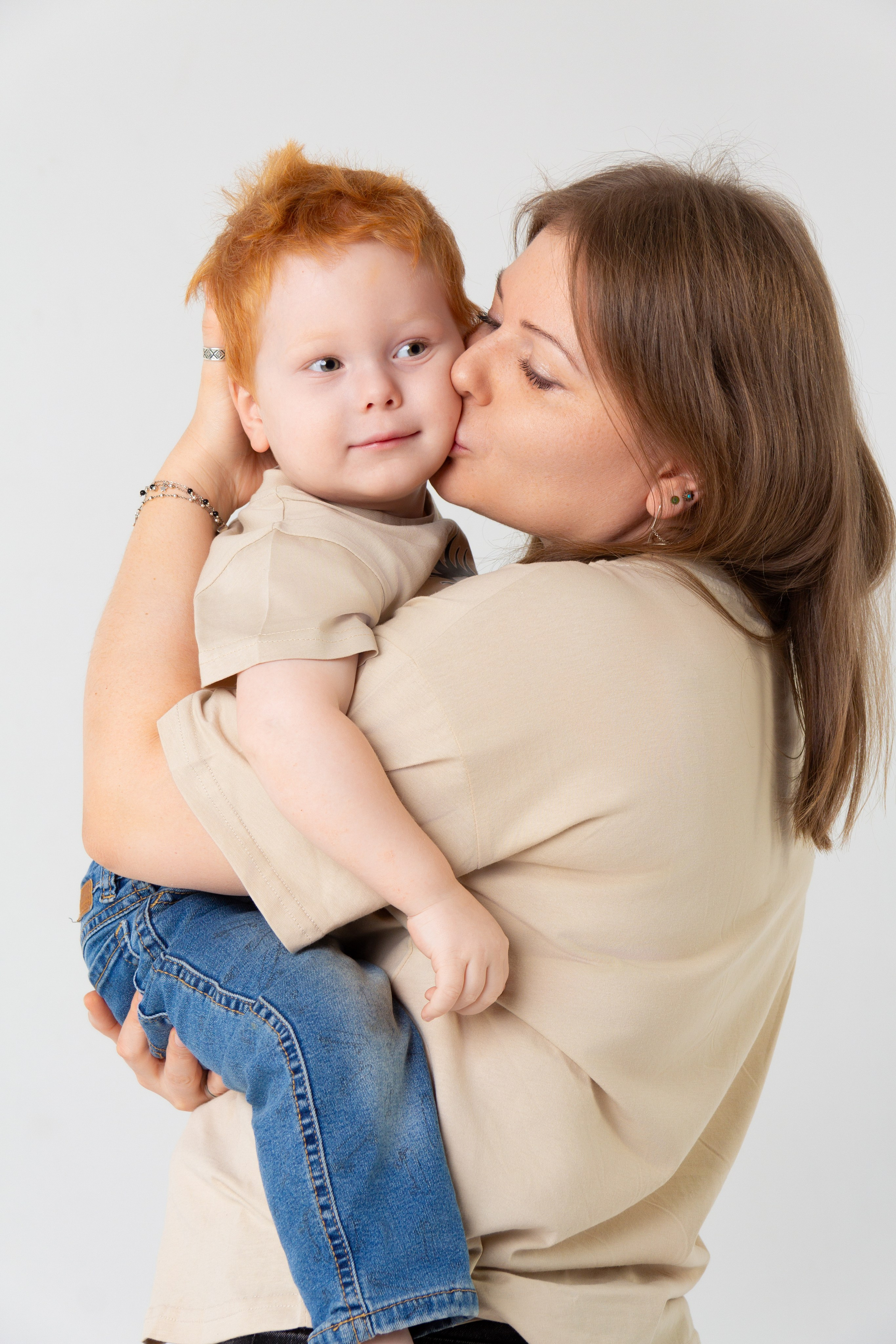 Мама целует своего младшего сына.