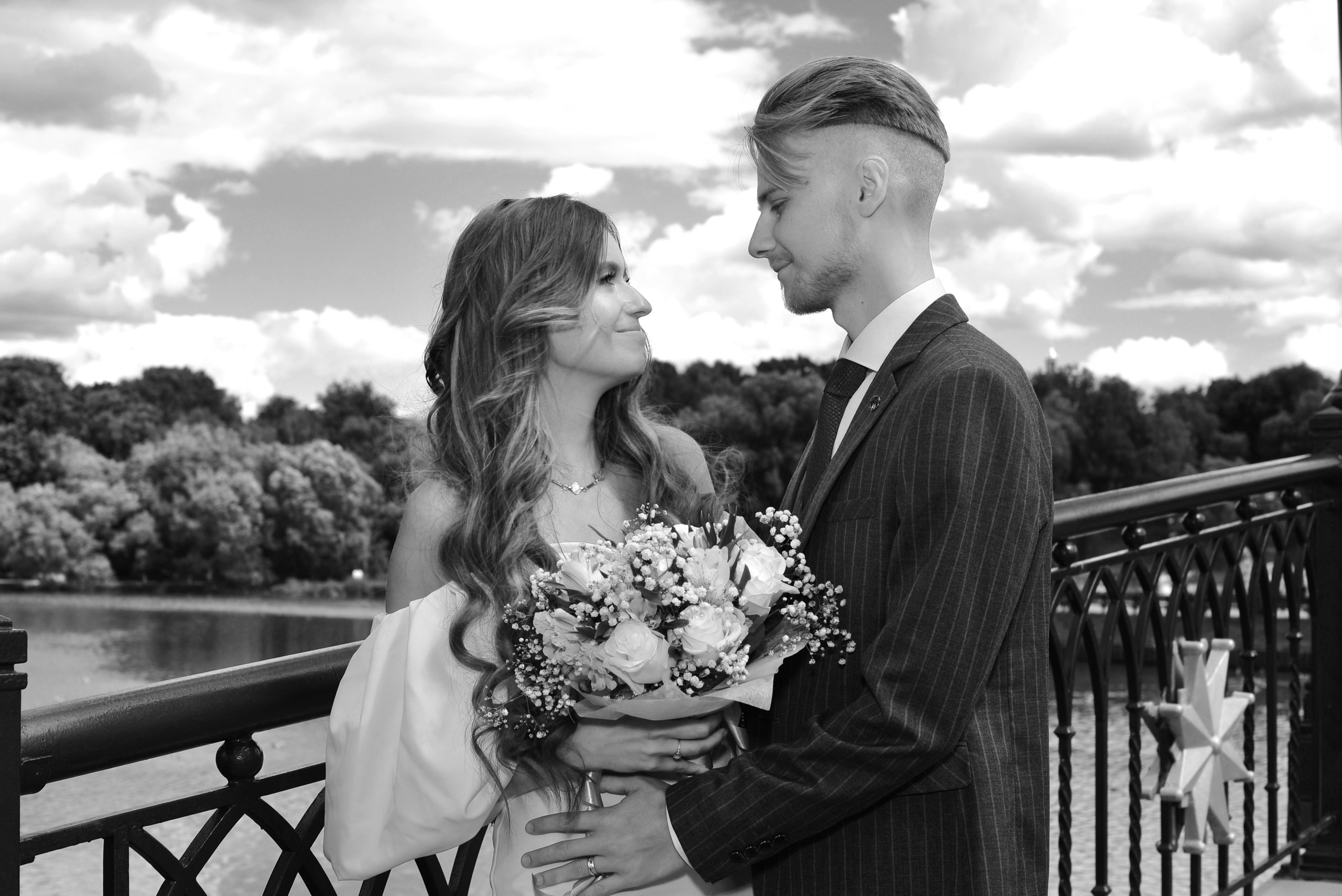 Свадьба в Царицыно летом, новобрачные смотрят друг на друга на мосту, чёрно-белая фотография