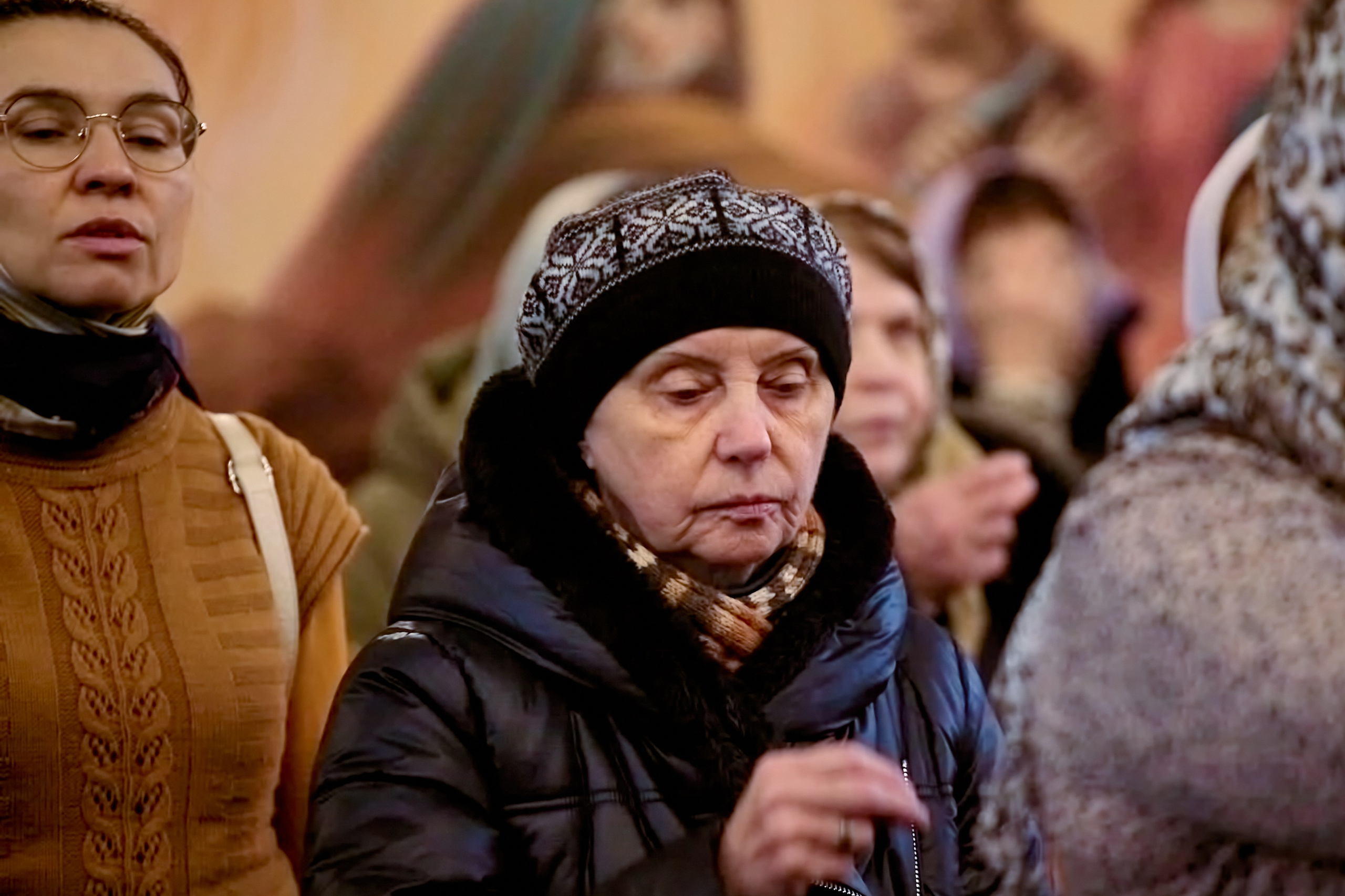 Женщина стоит в храме с молитвой на устах