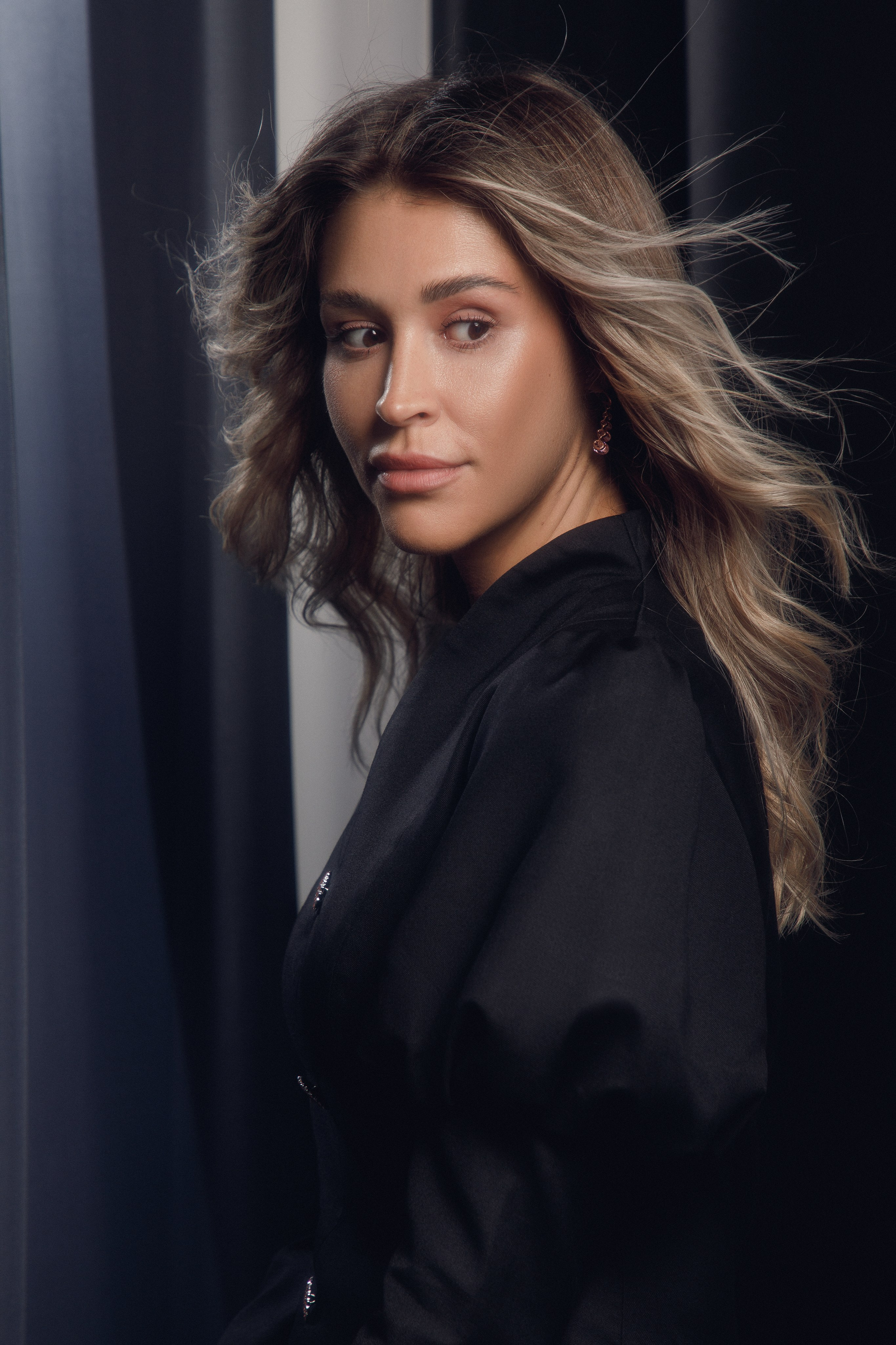 Портрет в профиль: девушка с красивыми развивающимися волосами в стильном платьем.