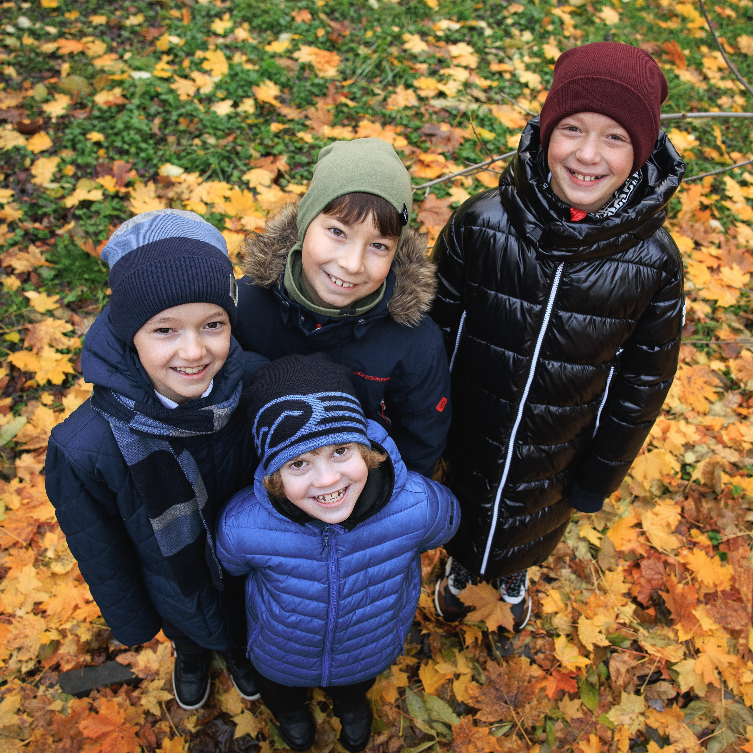 Четверо мальчиков позируют на осенней прогулке в парке