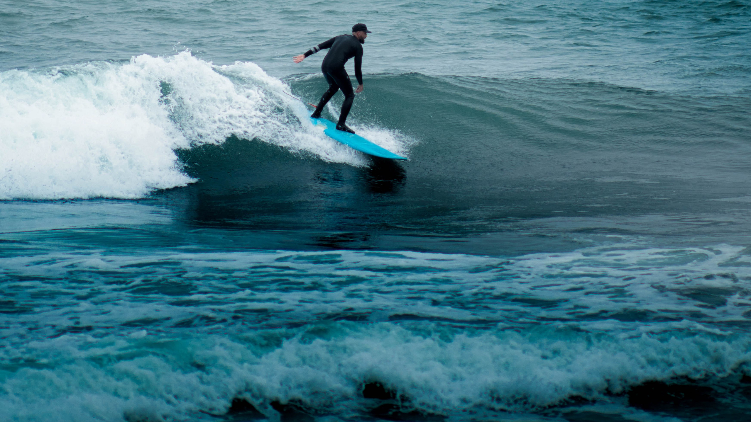 Сёрфер едет по волне во время занятия серфингом