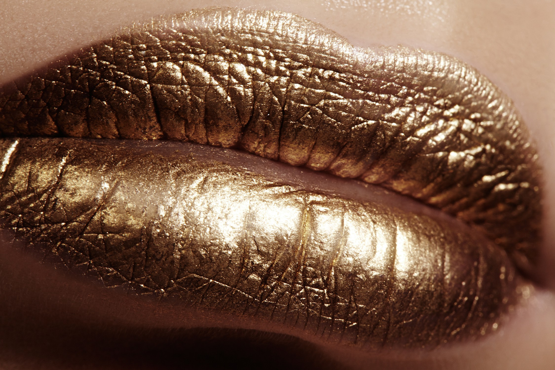 Perfect closeup of shiny gold metallic lip makeup 