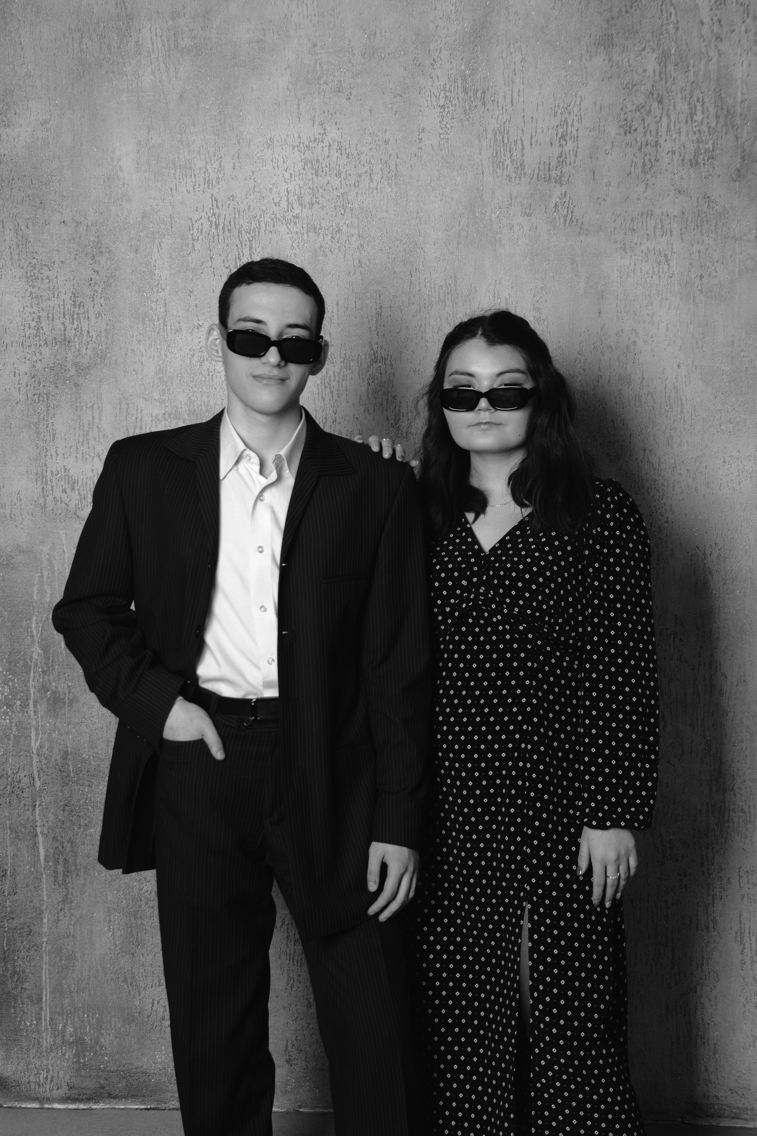 парная фотосессия, серьезные  парень с девушкой в черных очках и классических костюмах