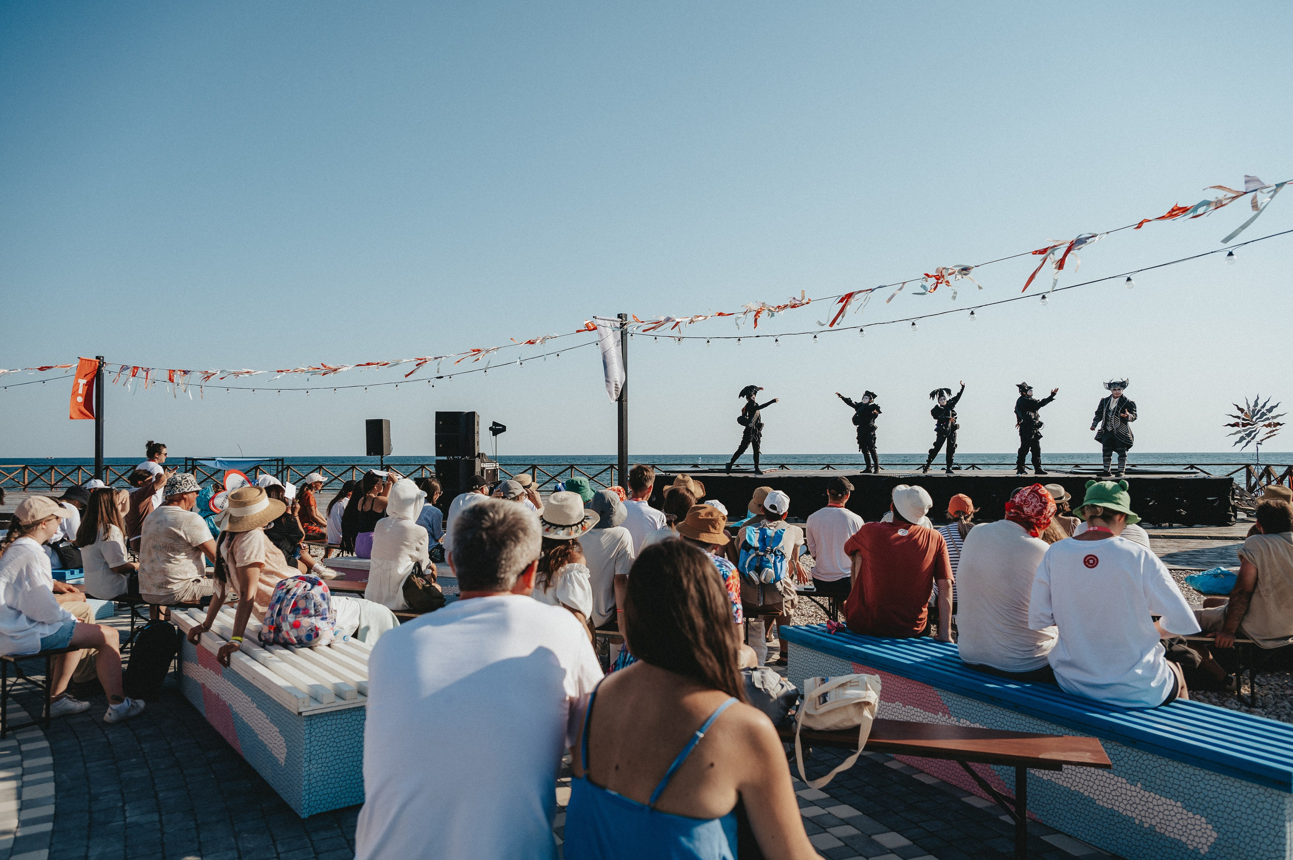 Событийная съемка театрального перфоменса у моря - общий план масштаба со стороны зрителей