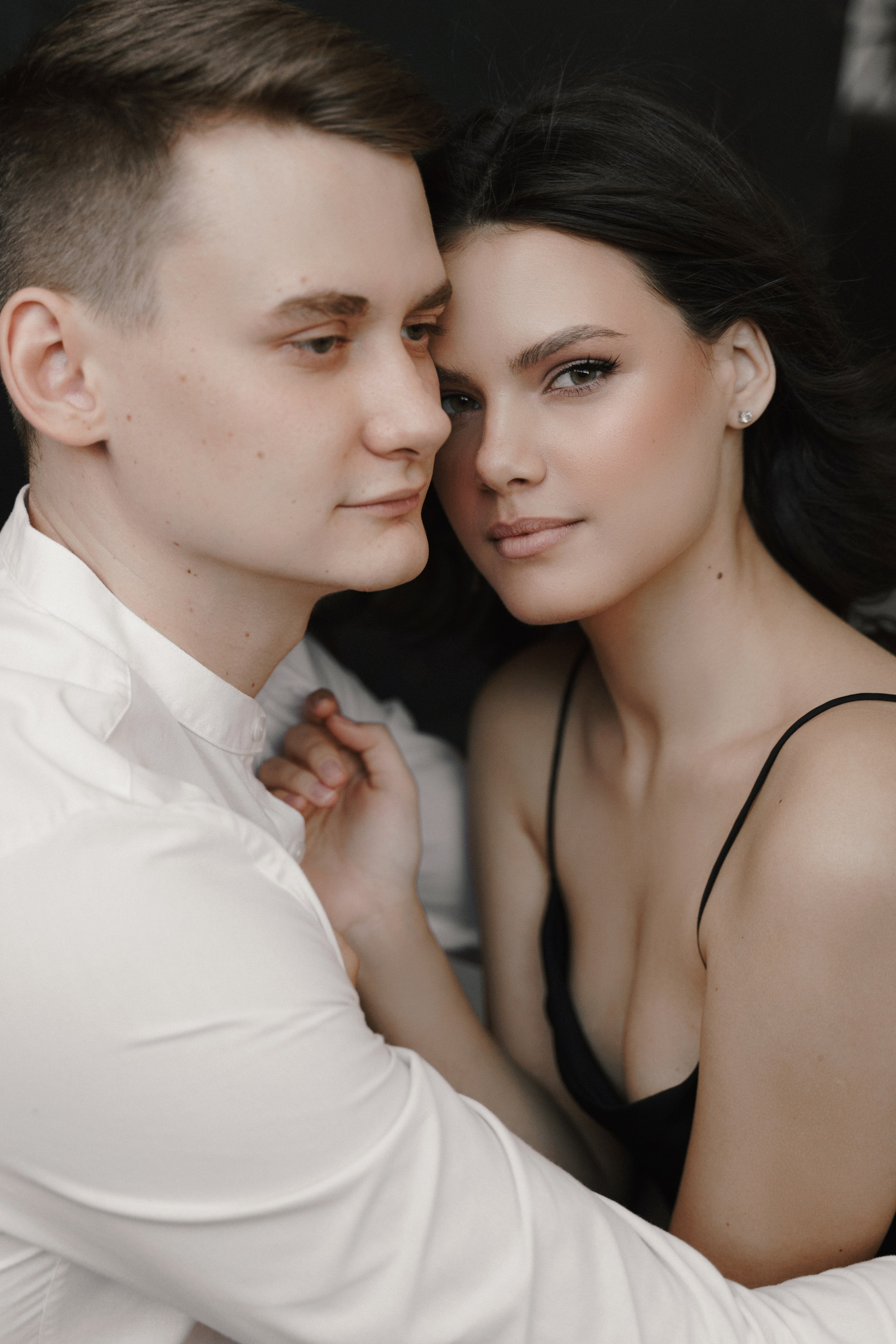 Парень обнимает девушку и она нежно смотрит в кадр