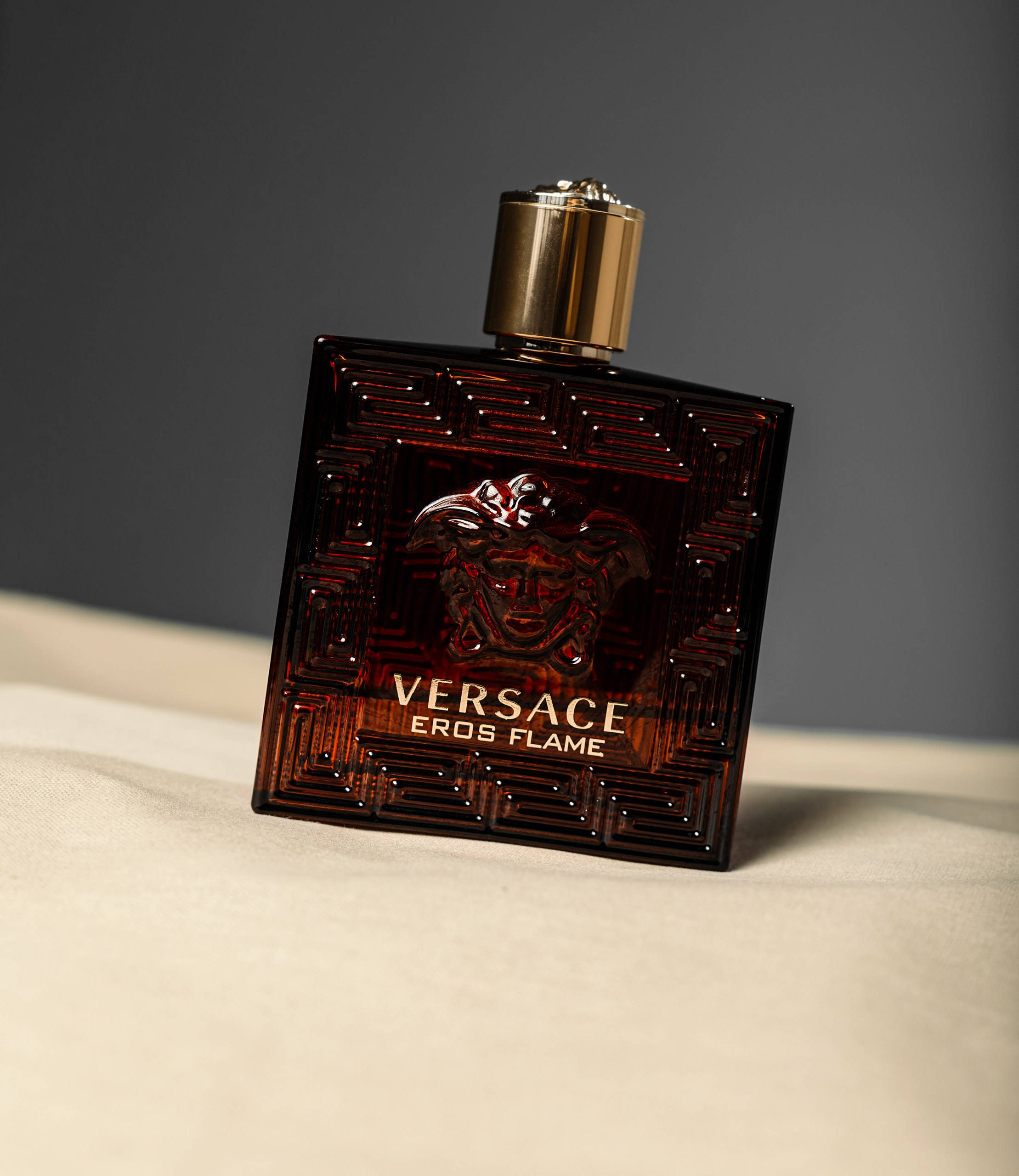 Съемка предметки на бежевом фоне парфюма Versace eros, духи на бежевом фоне в студии
