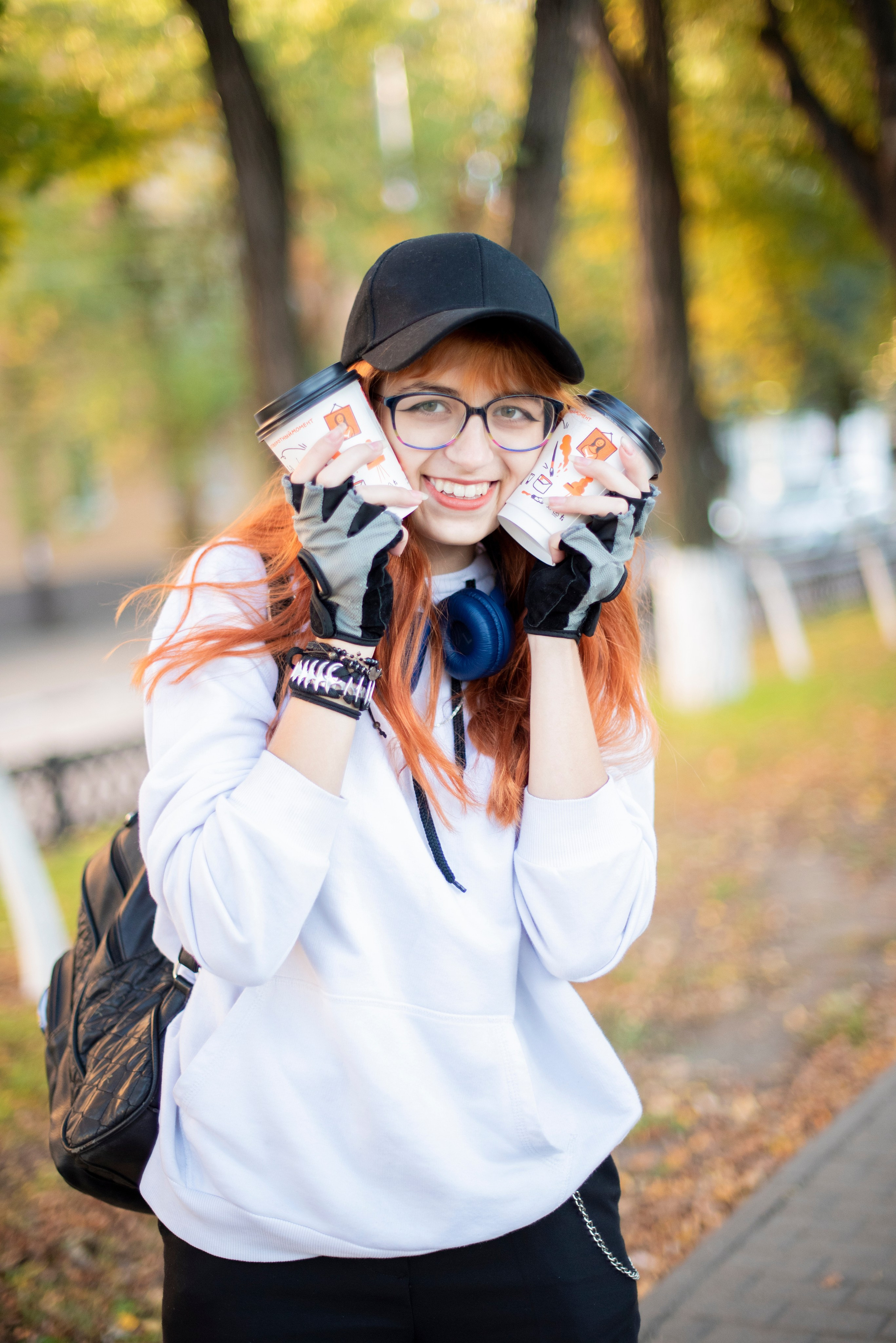 девушка-студентка. длинные рыжие волосы. белая кофта. очки. наушники. кепка. каменск-шахтинский