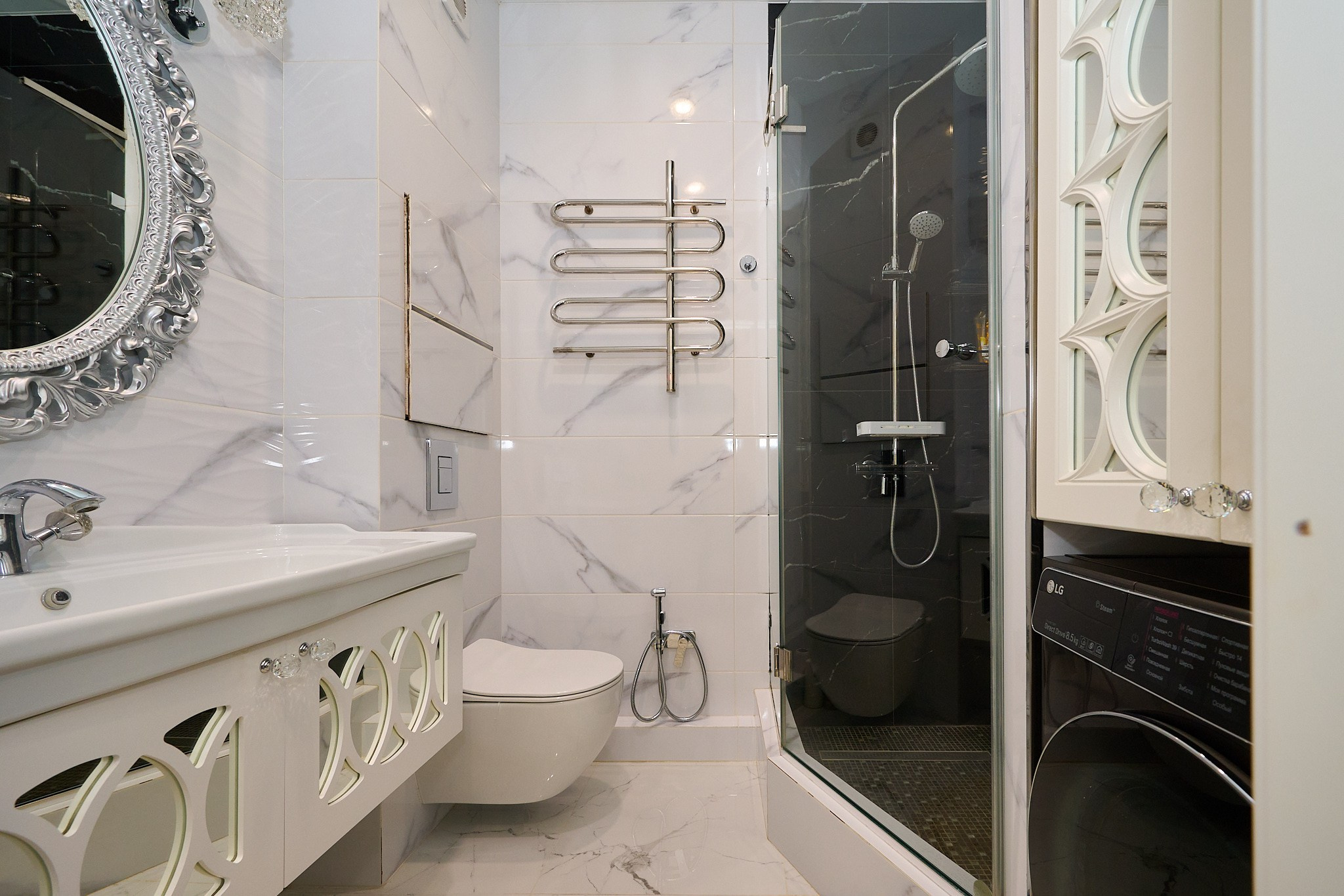 ванная комната светлые плиты душевая кабина светлая раковина большое круглое зеркало