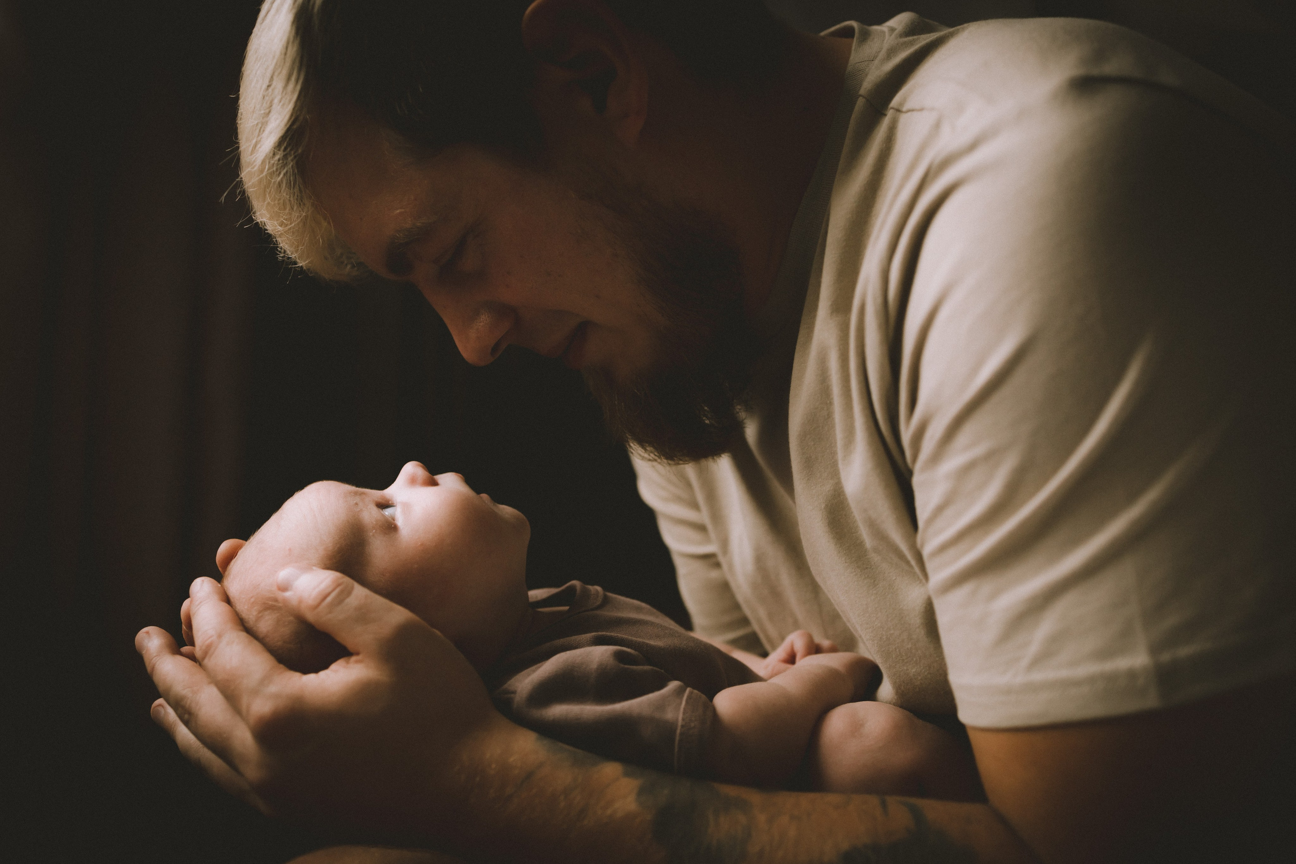 newborn фотосессия Санкт-Петербург папа держит сына на руках и малыш смотрит на папу