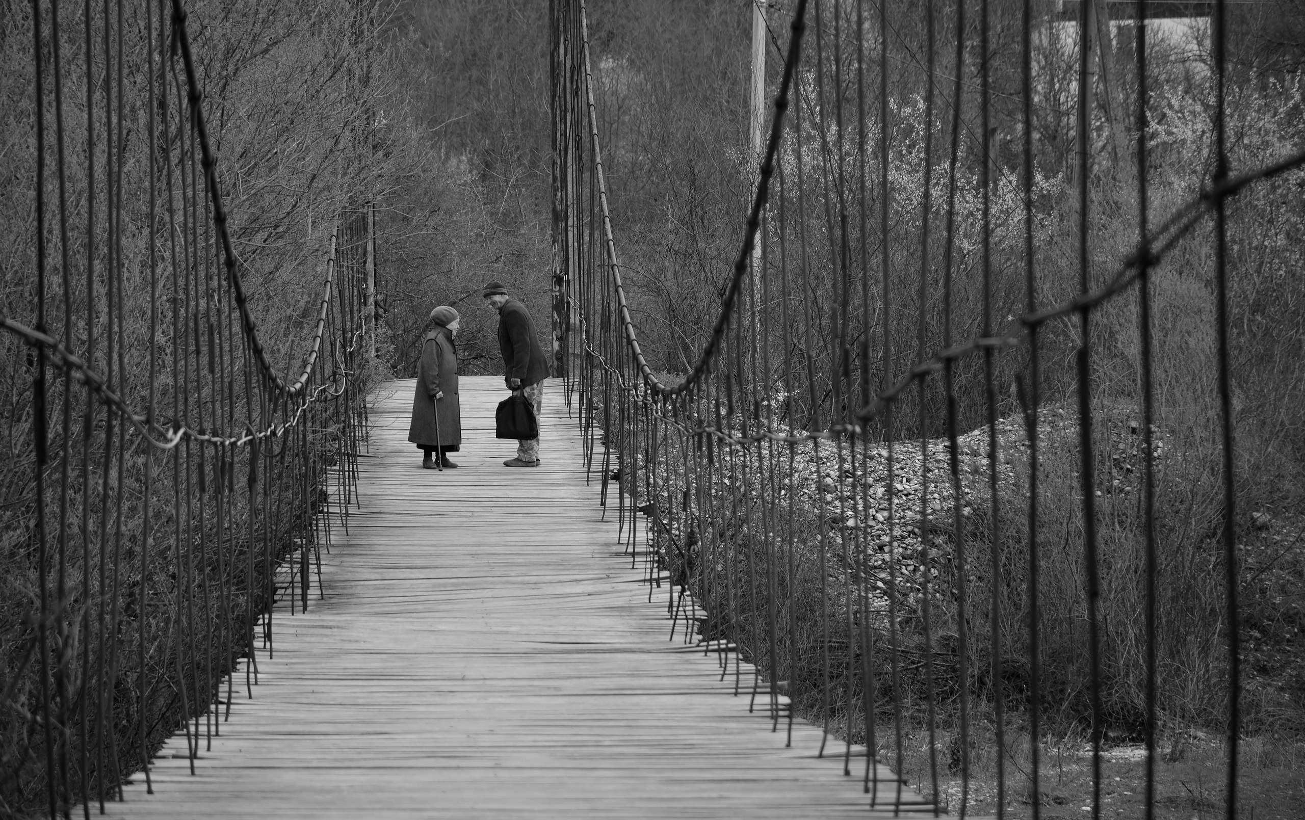Мужчина и женщина обмениваются новостями на горном подвесном мосту, Михайловский перевал