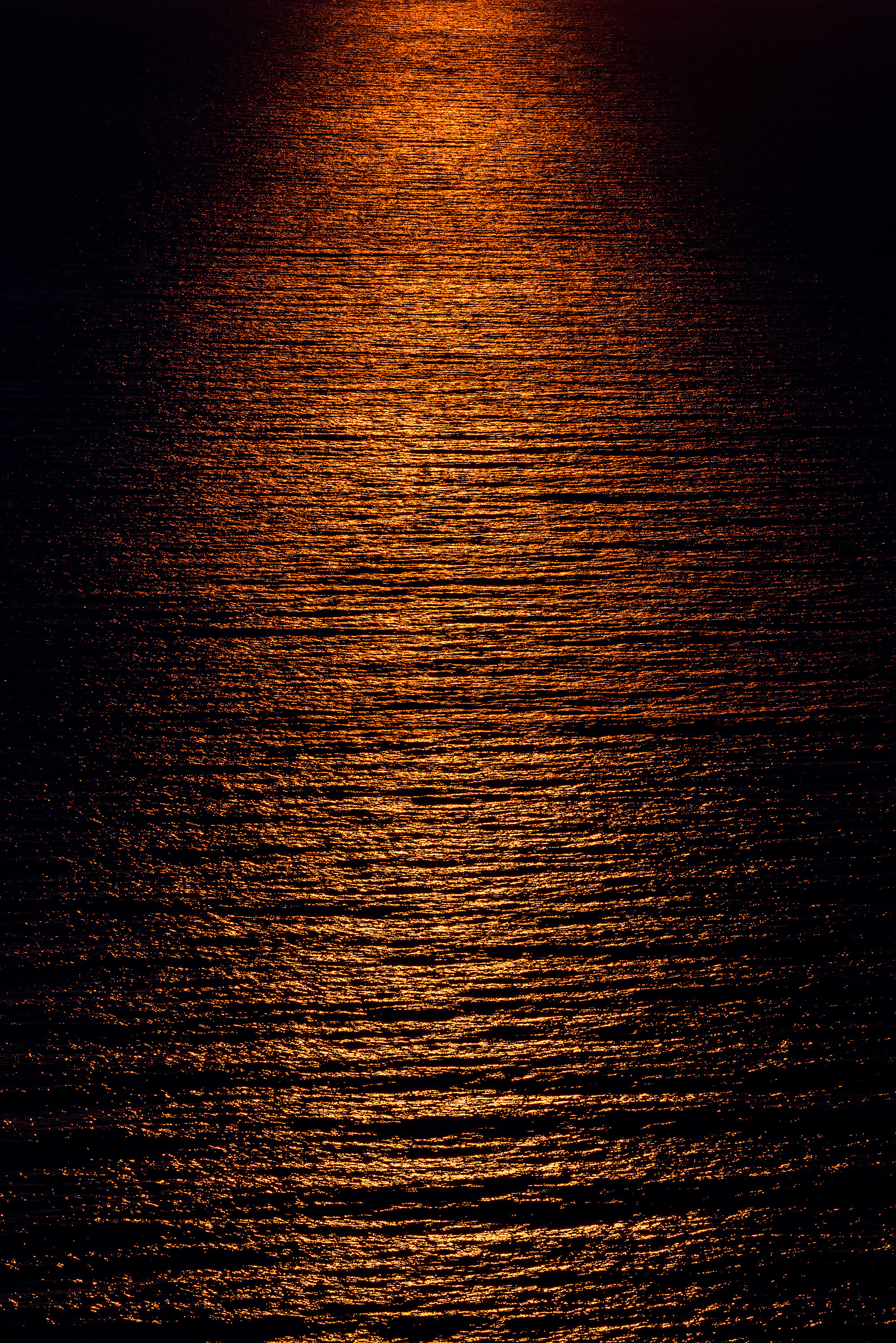 Рябь с красными отблесками на поверхности моря