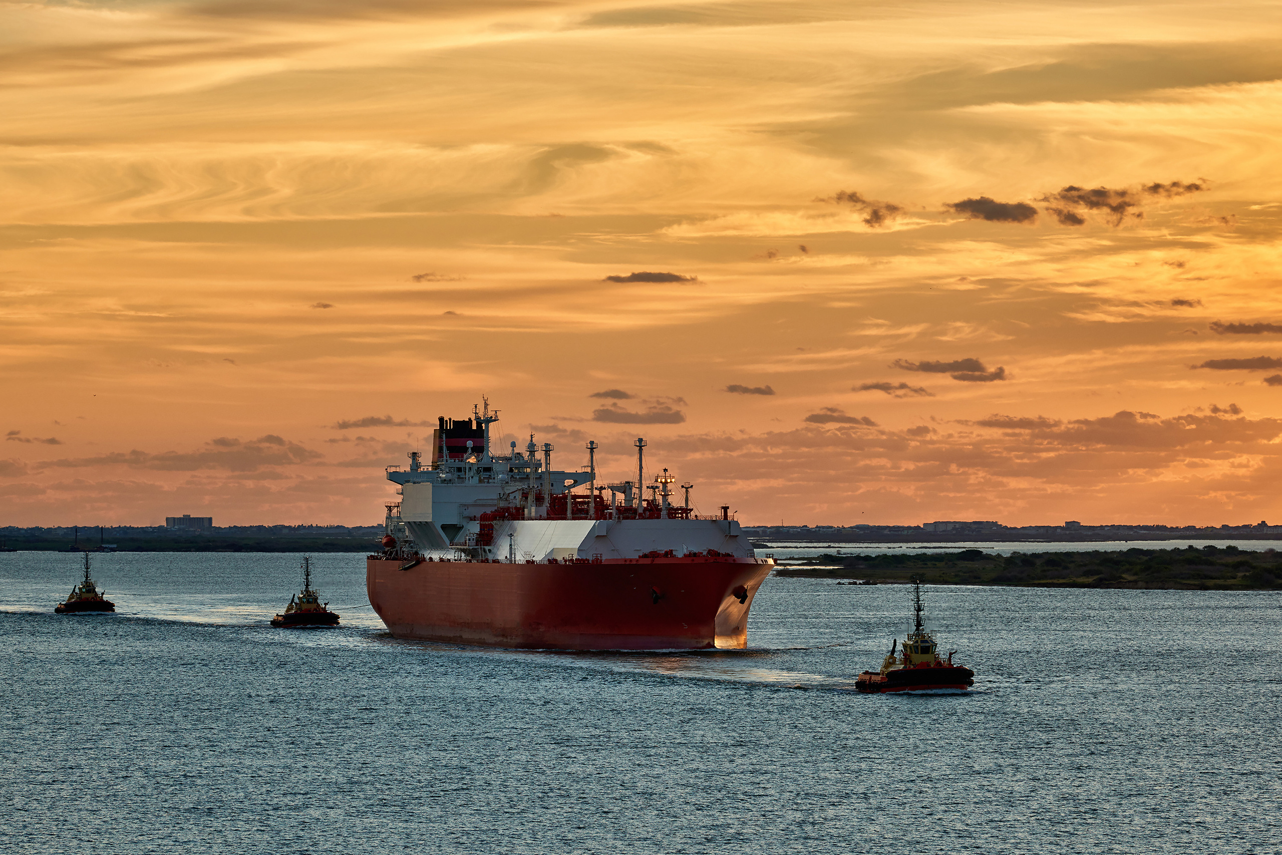 Танкер-газовоз с тремя буксирами заходит в порт