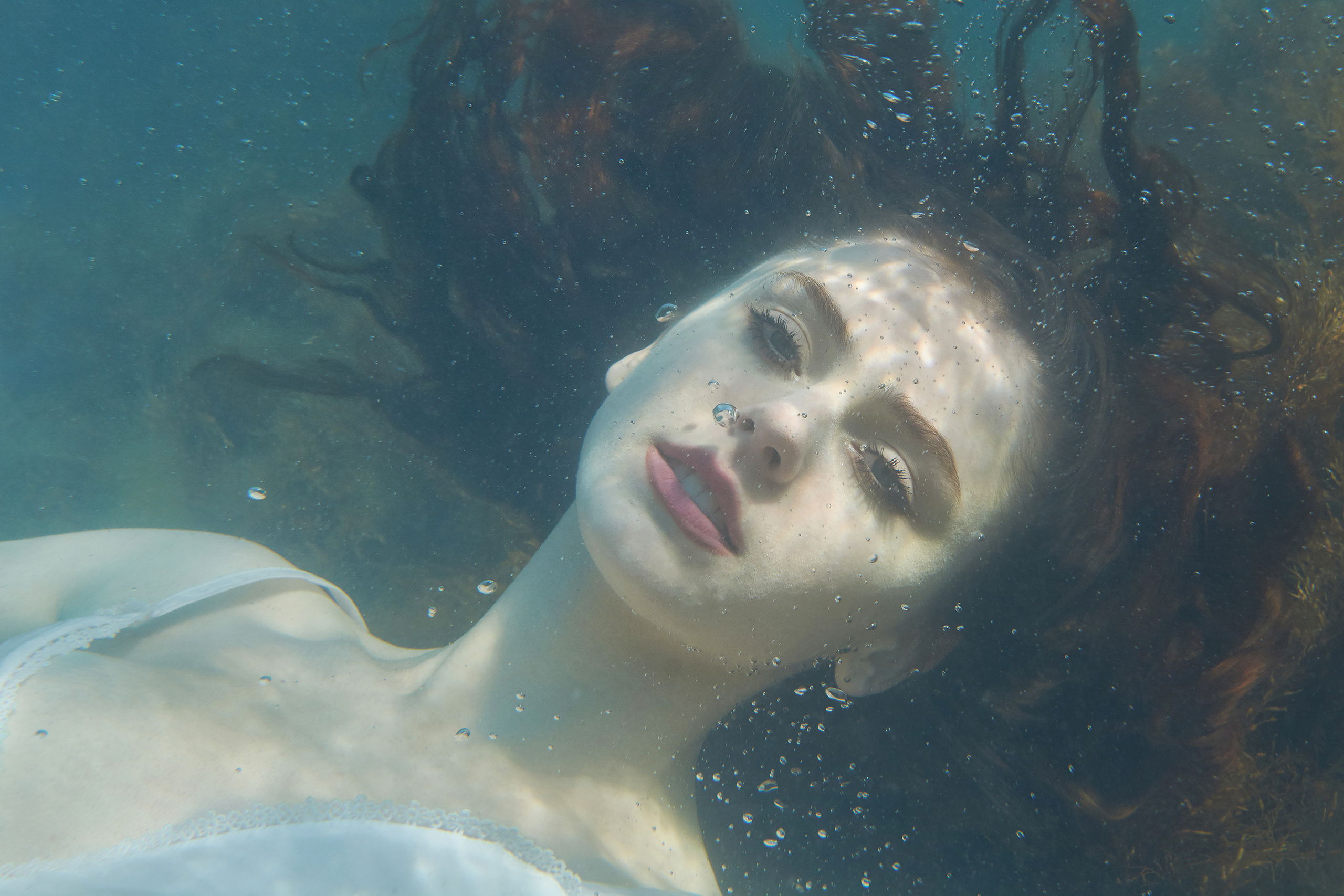 Девушка, лежащая на дне, под водой