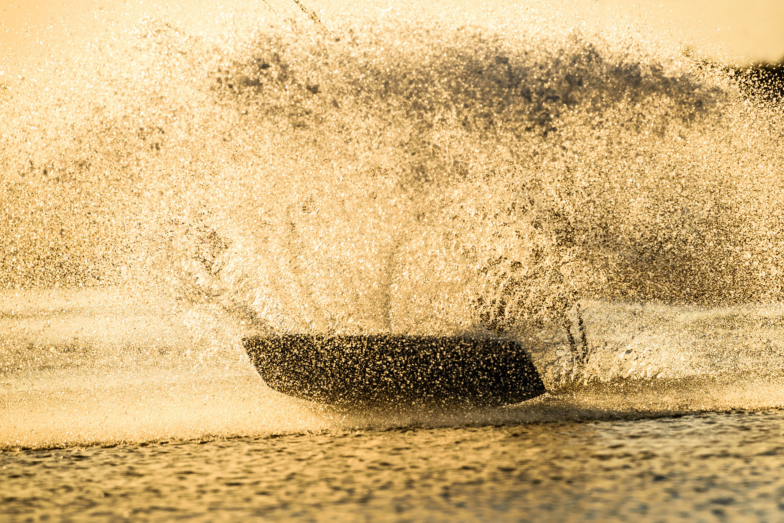 Брызги от кайт доски в свете заходящего Солнца