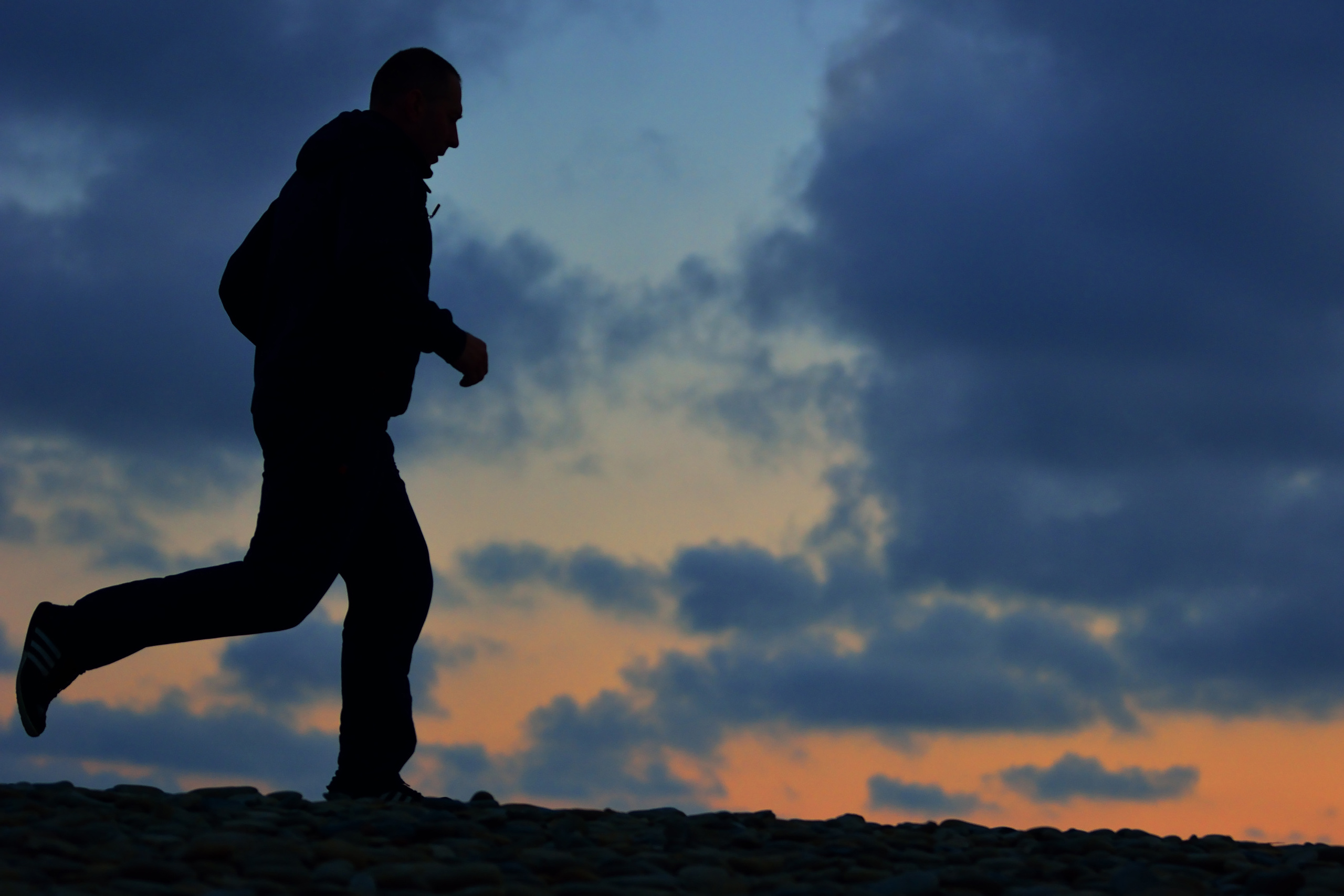 Мужчина за утренней пробежкой вдоль морского пляжа, Новороссийск