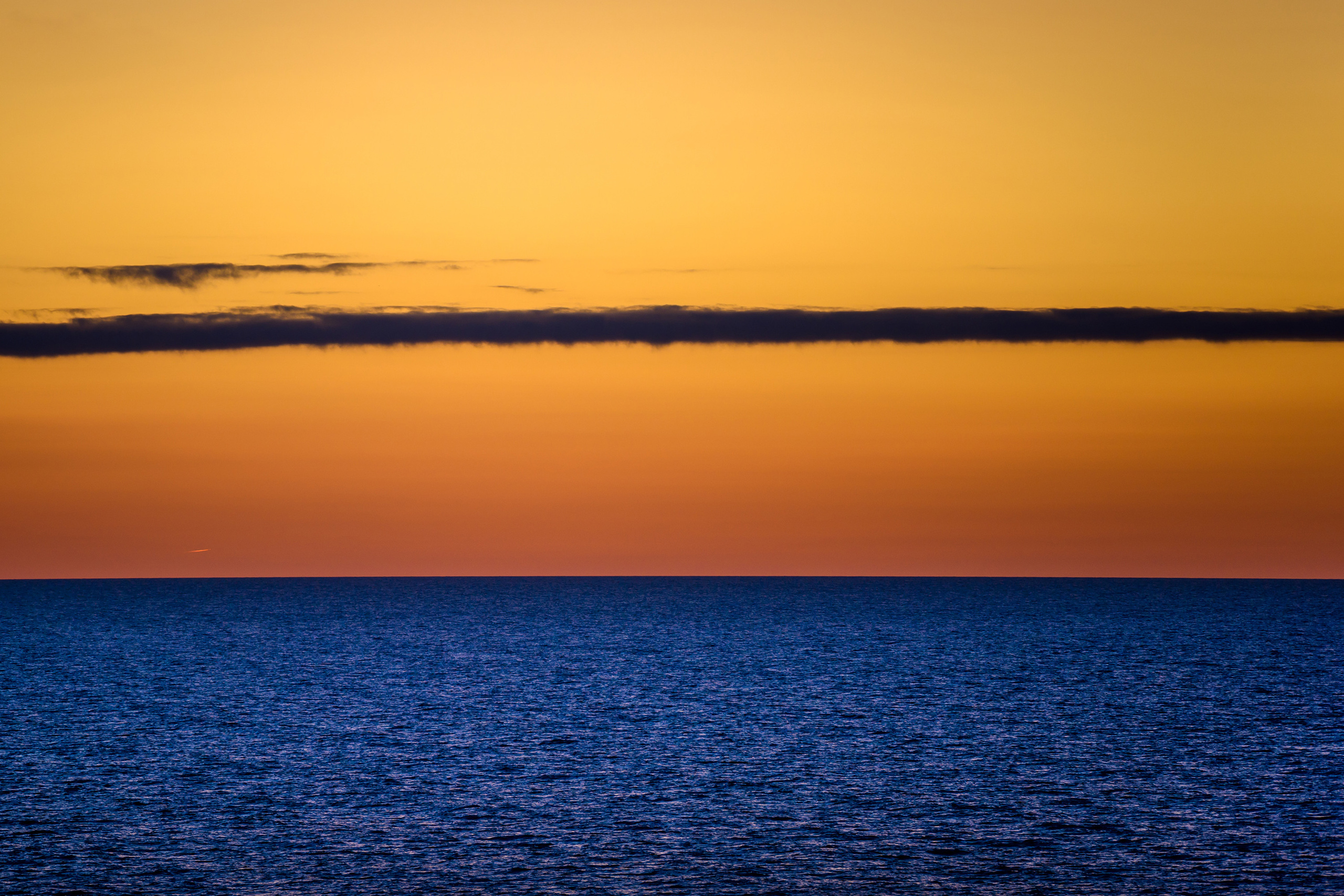 Тонкое длинное облако на фоне заката