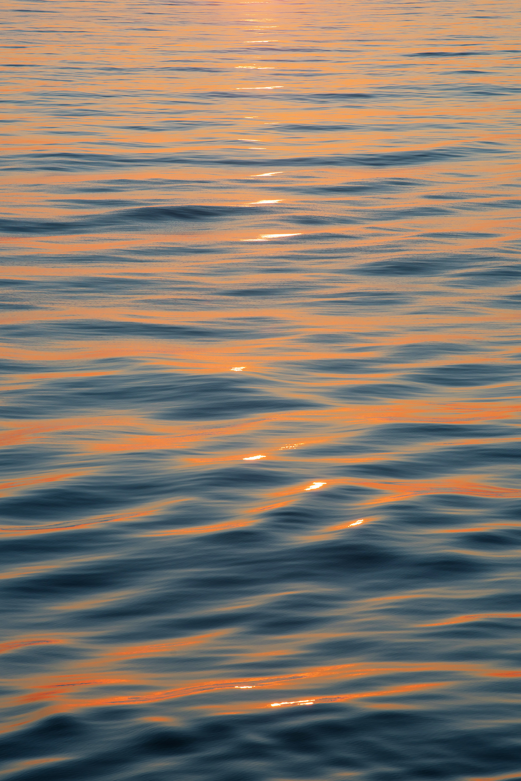 Рябь с розовыми отблесками на поверхности моря