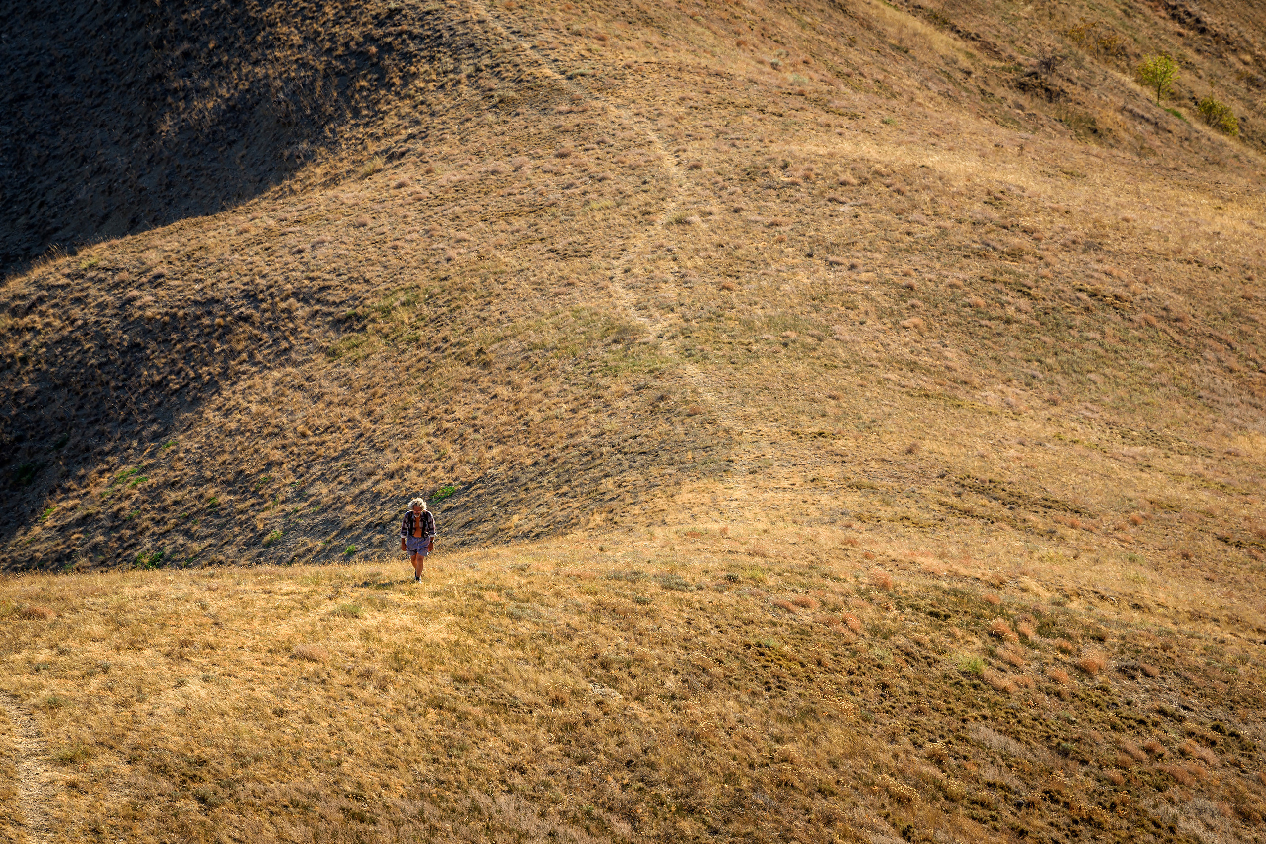 Один мужчина поднимается в гору по тропе